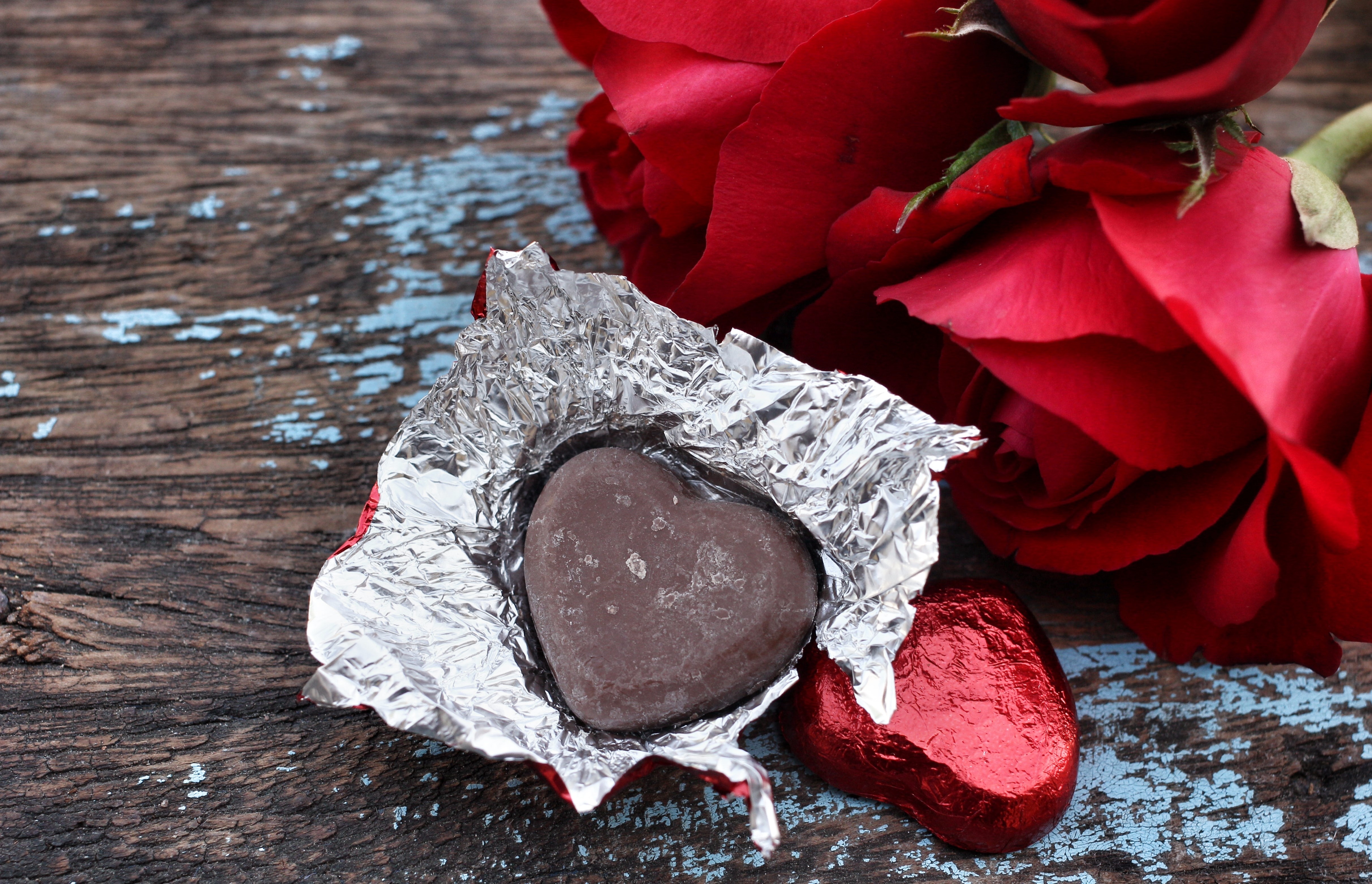 Heart-shaped chocolates and red roses on wood HD Wallpaper
