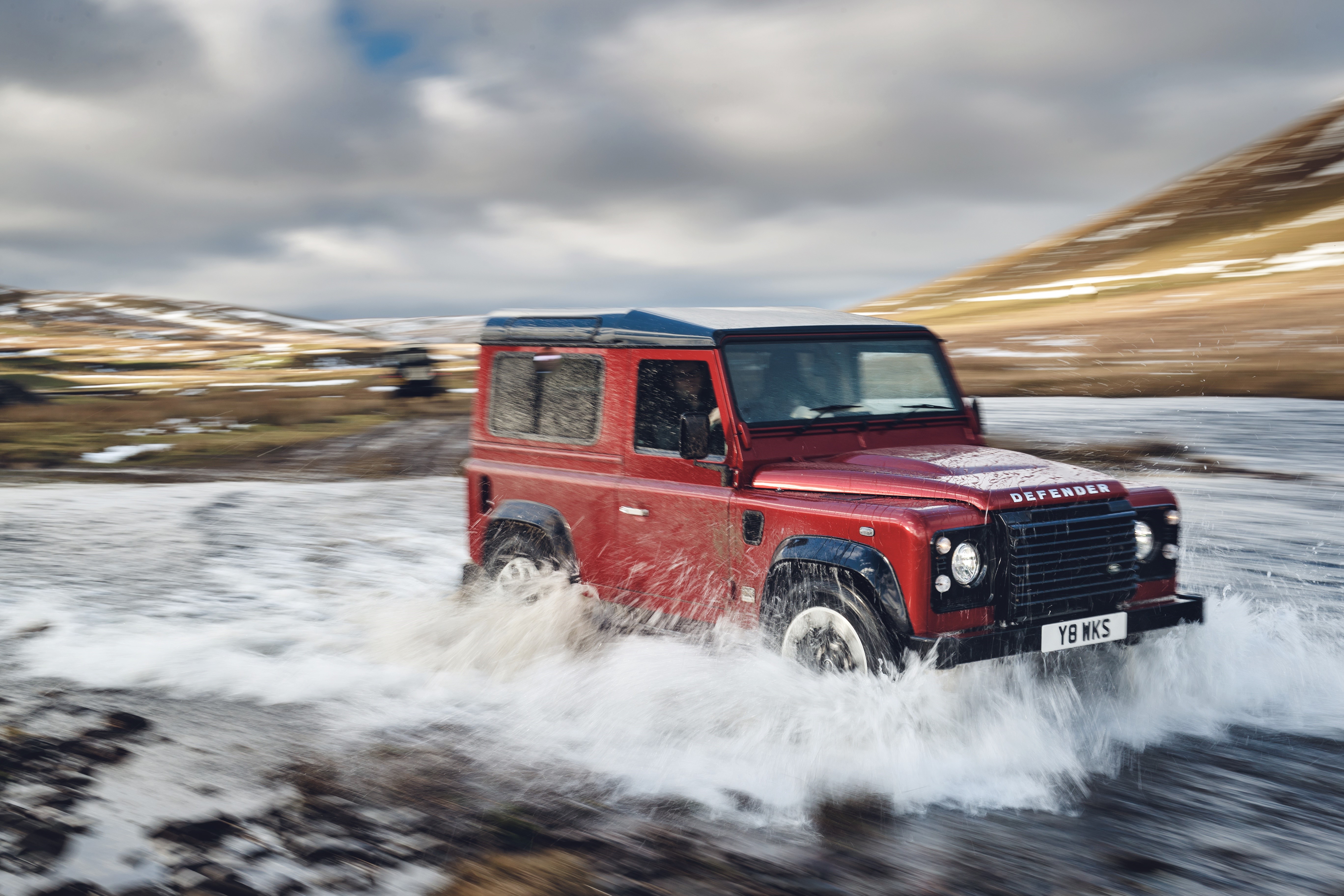 Red Land Rover Defender Works V8 driving through water HD Wallpaper