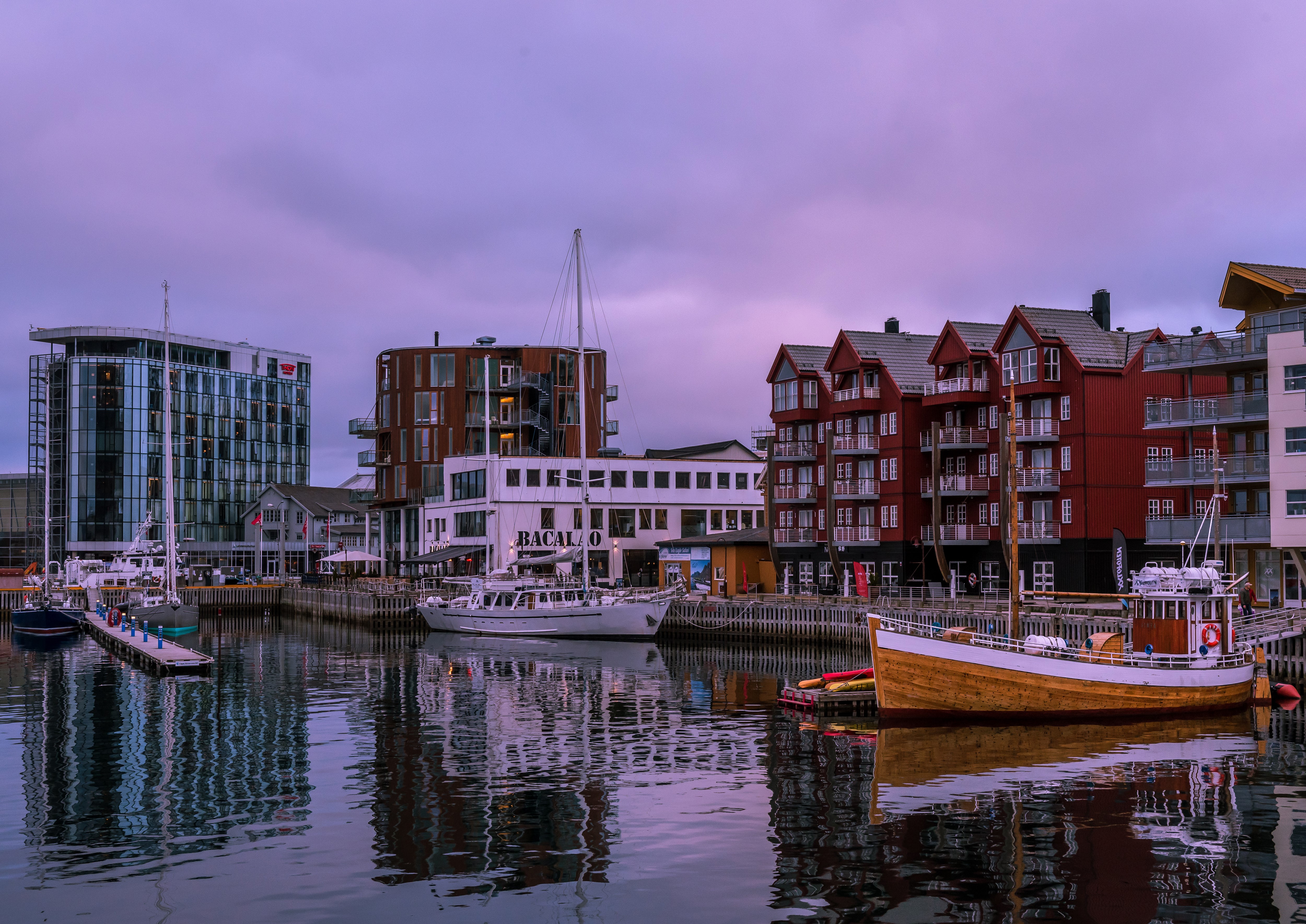 Boats docked in a harbor with modern buildings HD Wallpaper
