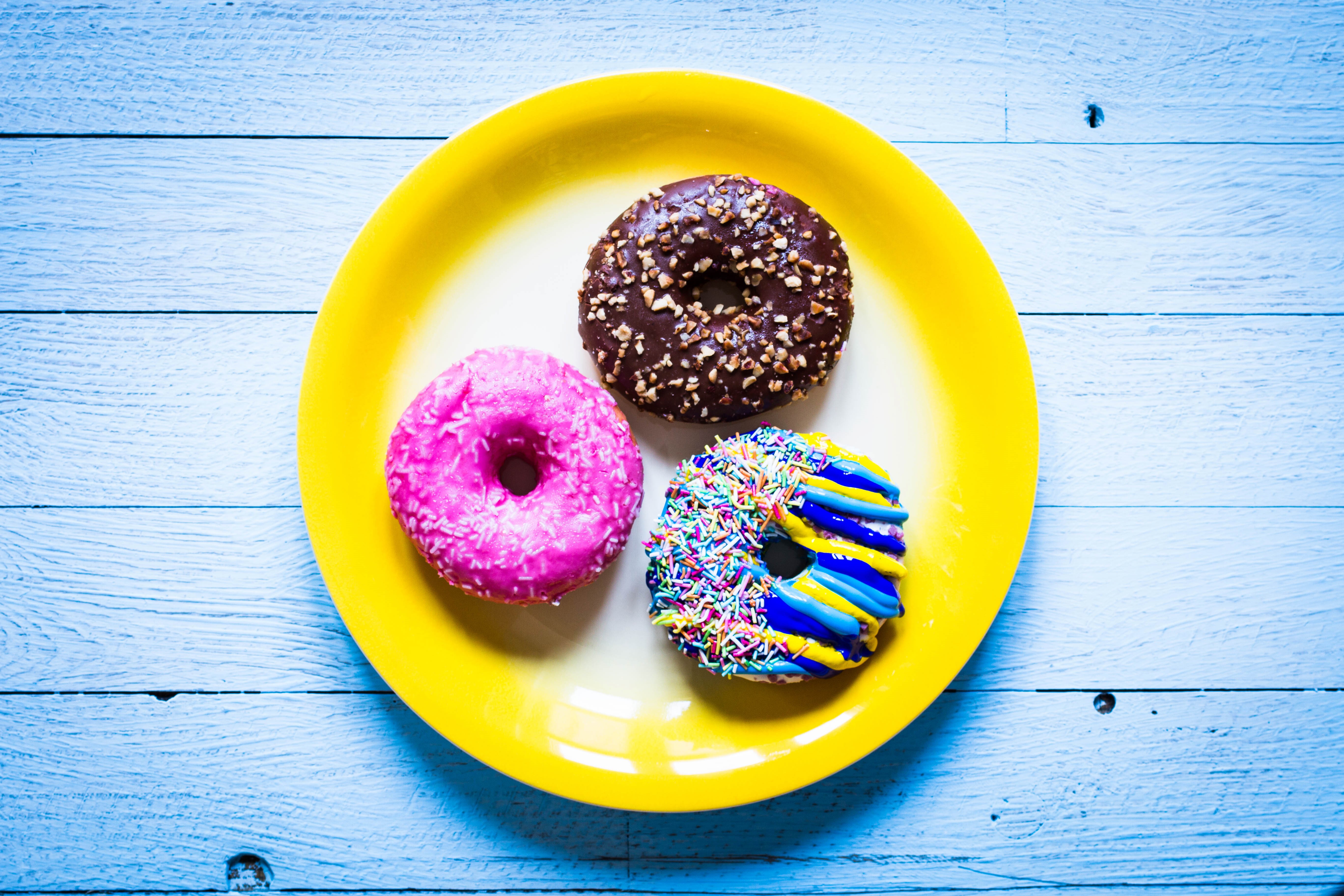 Three donuts on a yellow plate HD Wallpaper