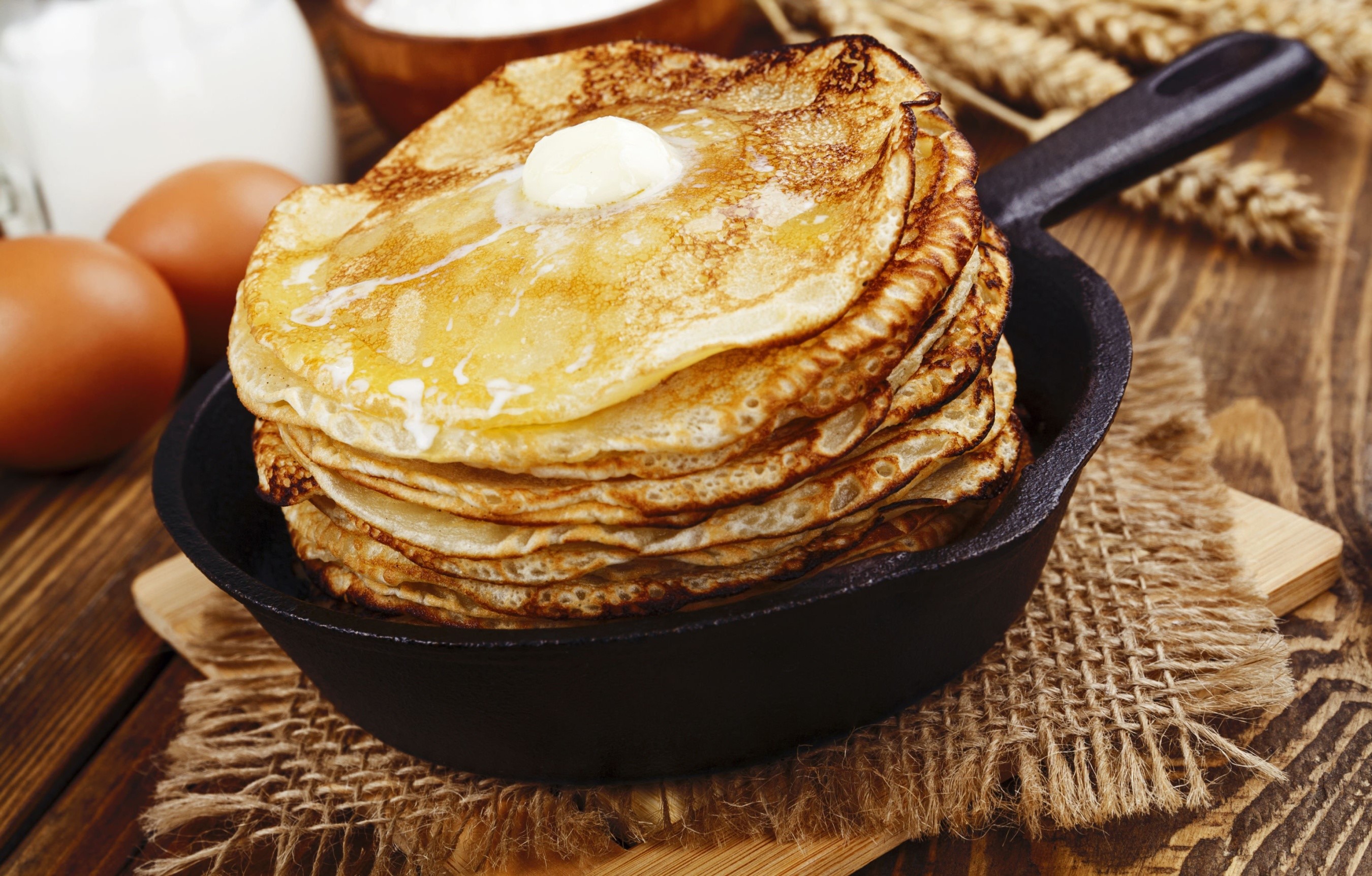 Stack of pancakes with butter in a frying pan HD Wallpaper