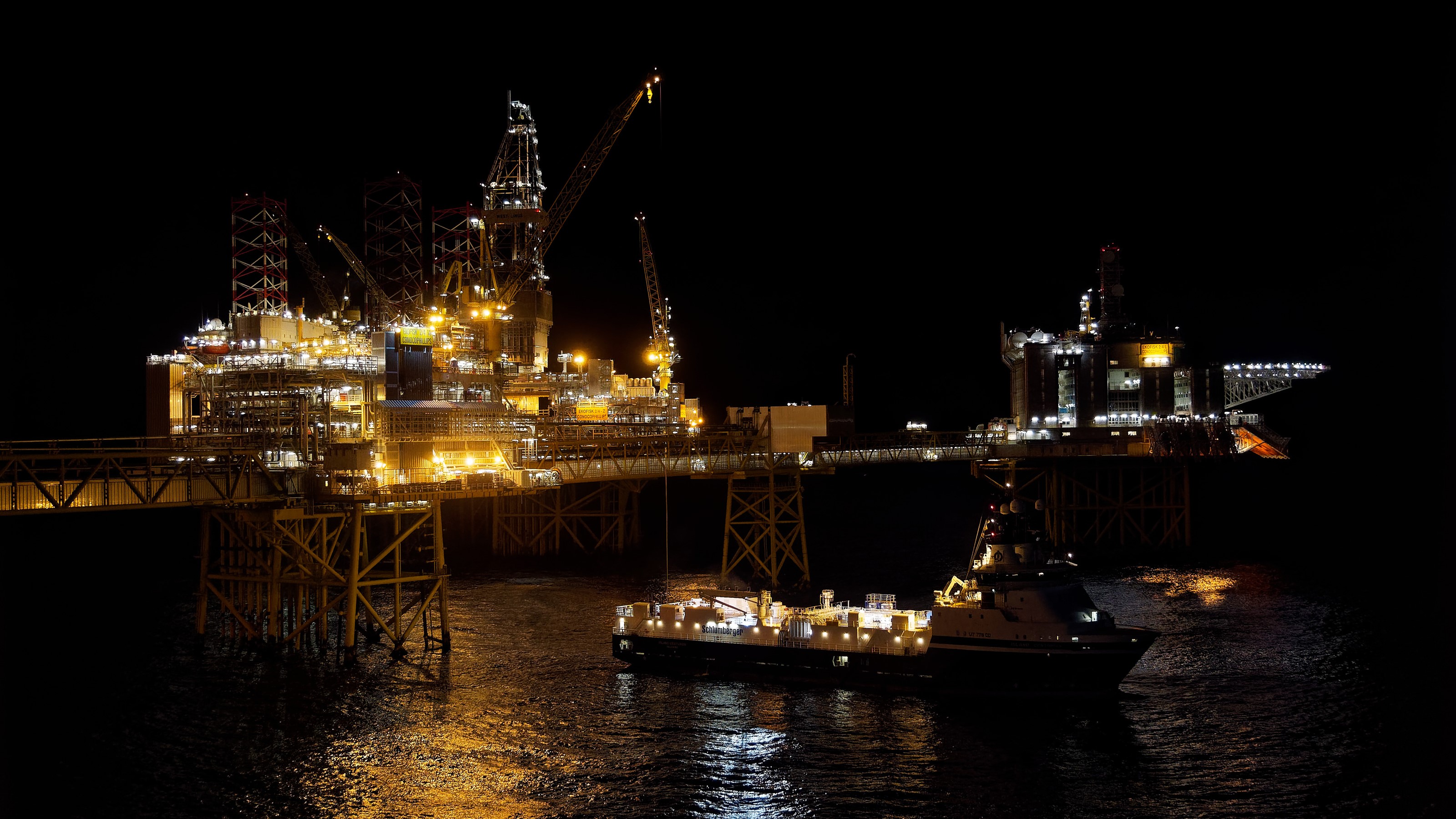 Offshore oil rig and ship at night HD Wallpaper