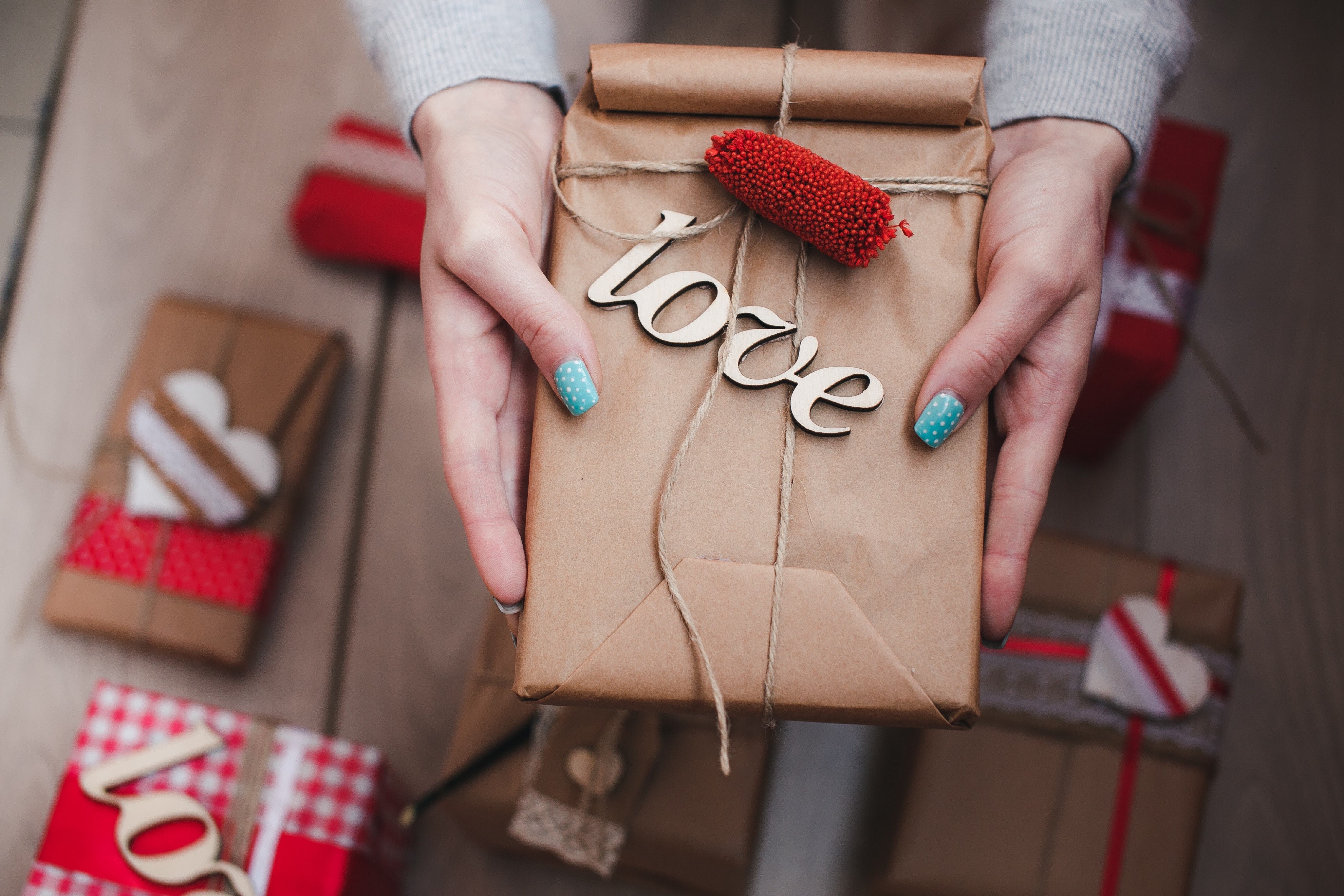 Hands holding a gift box with the word "love" HD Wallpaper