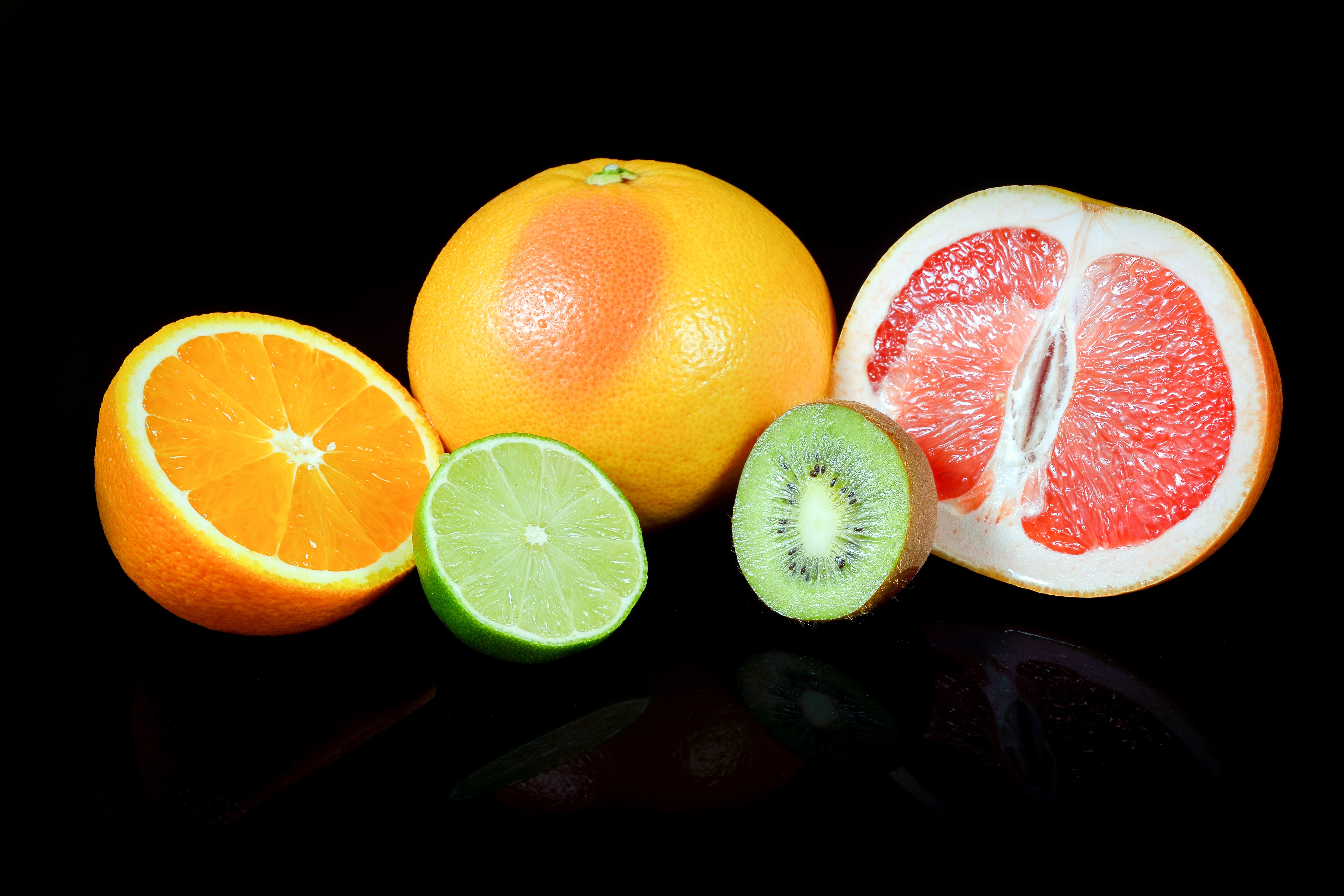 Citrus fruits and kiwi on black background HD Wallpaper
