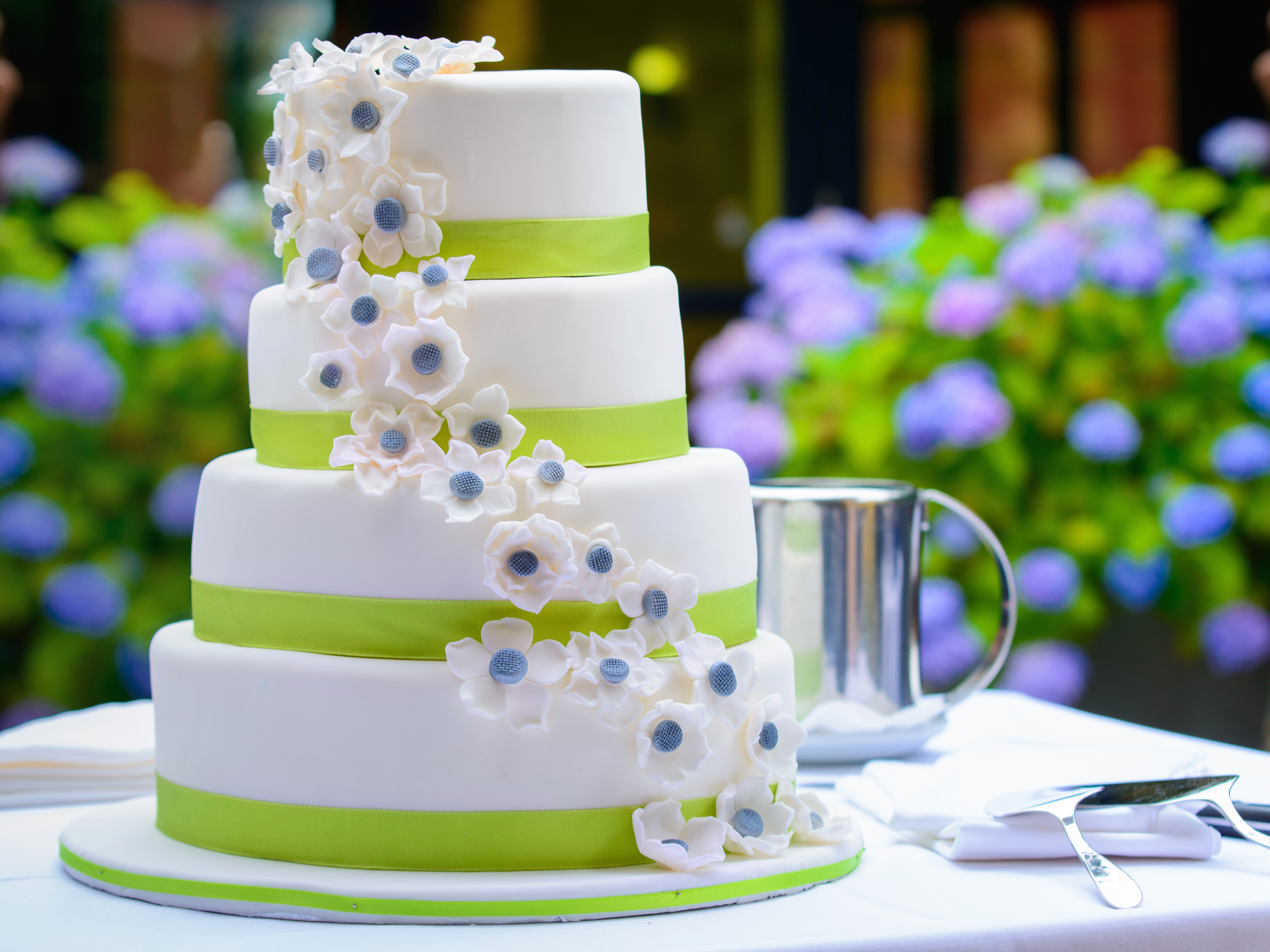 Four-tier white wedding cake with green ribbon and white flowers HD Wallpaper