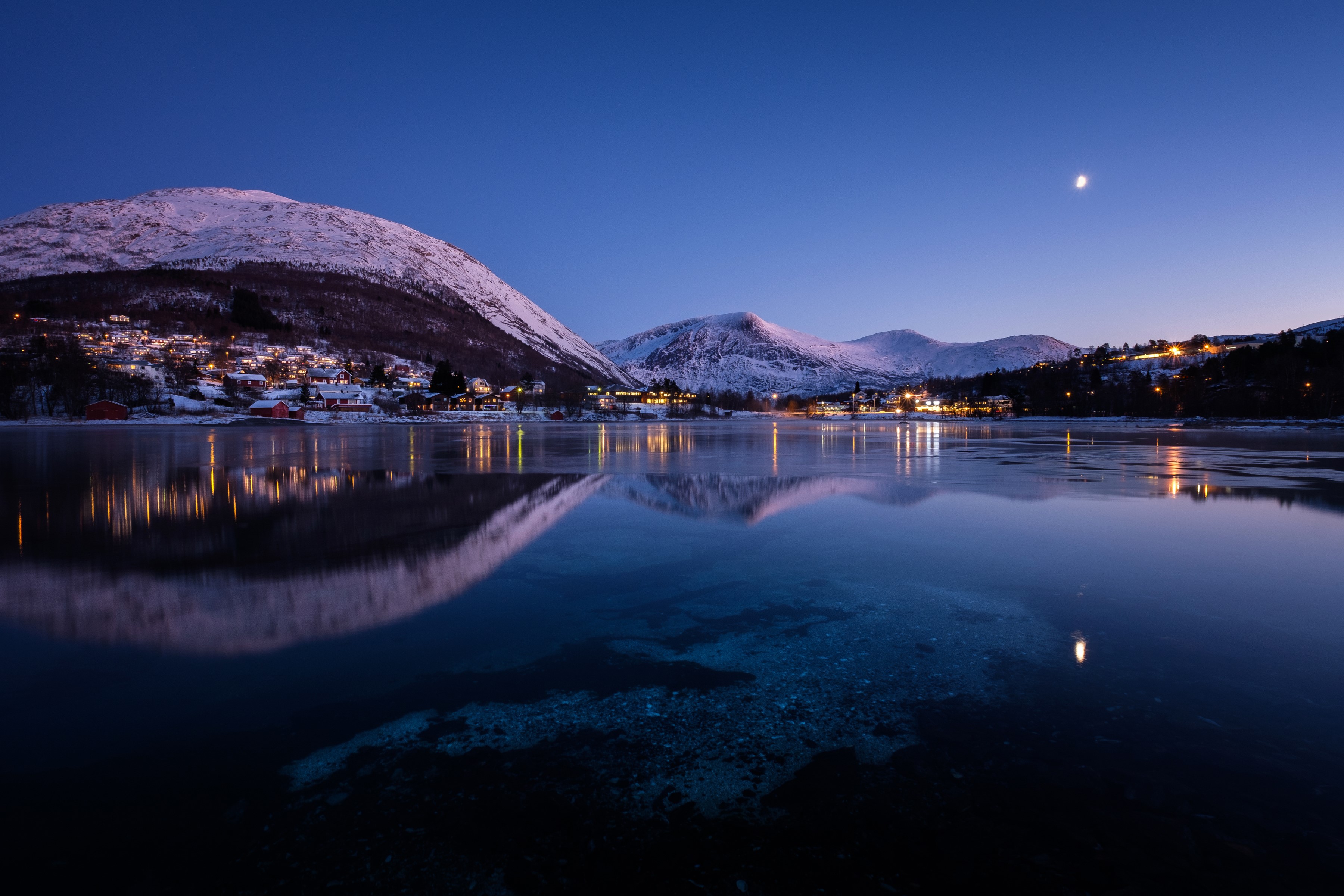 Straumen, Norway at night with snow-capped mountains and lake HD Wallpaper