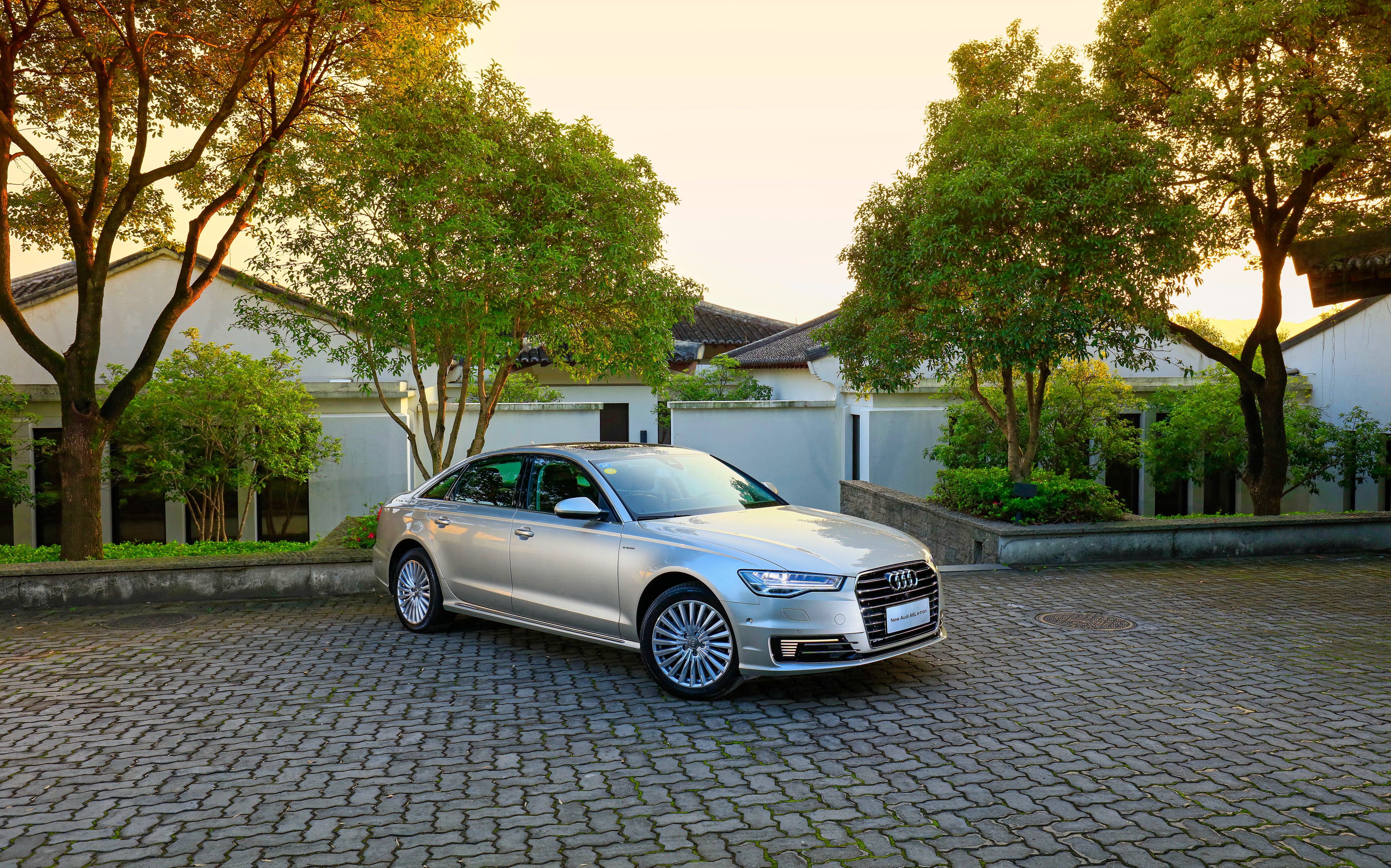 Silver Audi A6 L e-tron parked on cobblestone HD Wallpaper