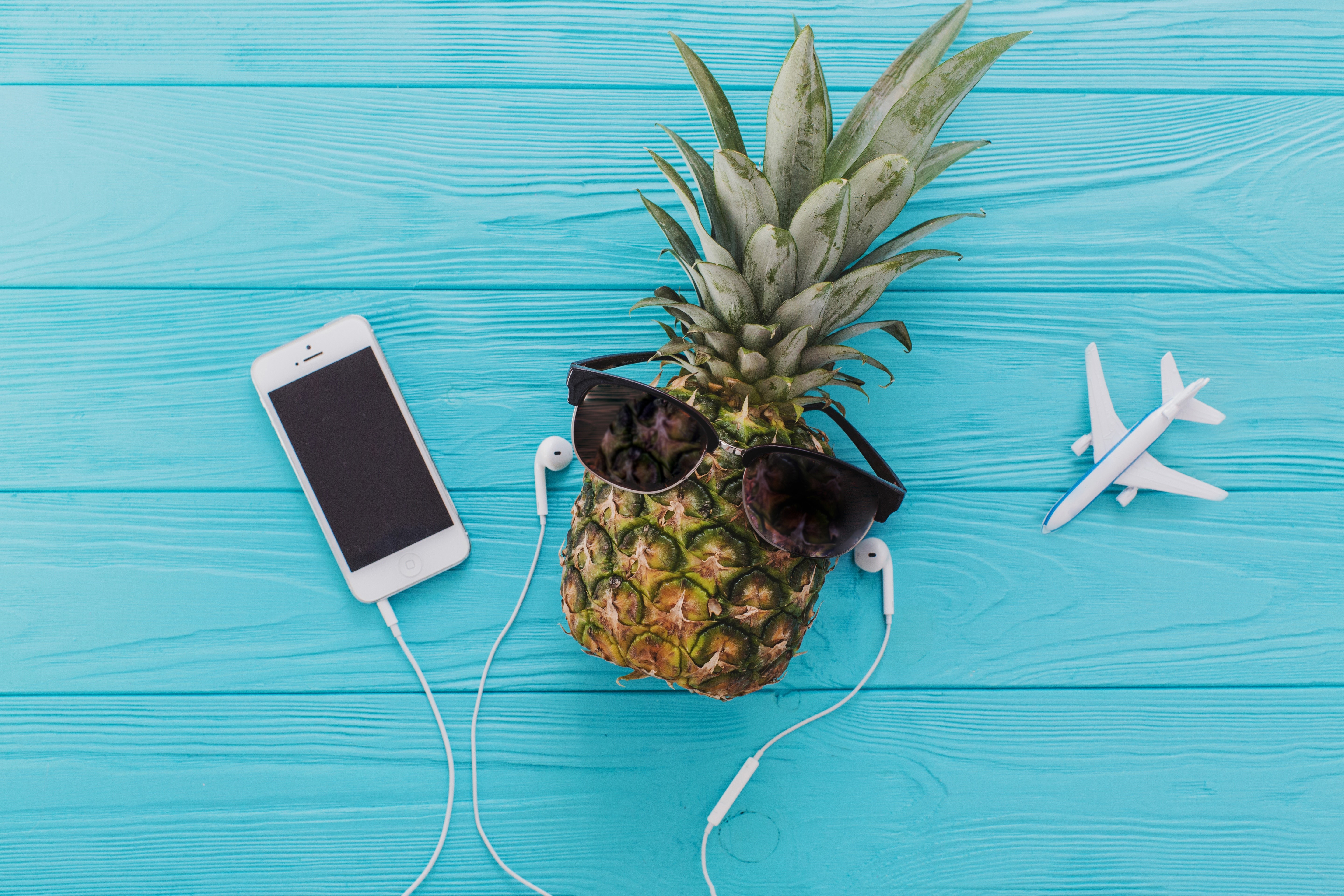 Pineapple with sunglasses, smartphone, headphones, and airplane HD Wallpaper