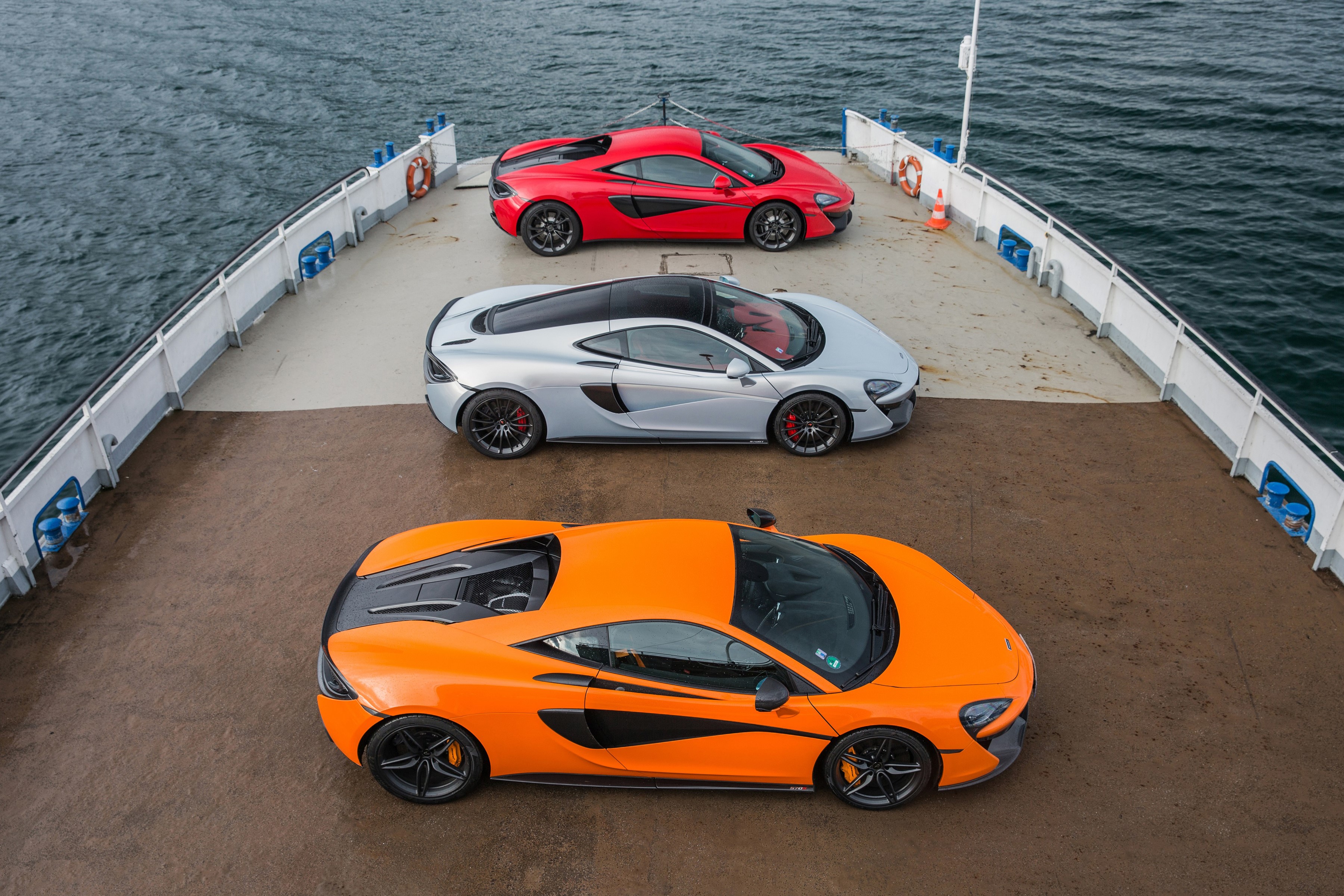 Three McLaren sports cars on a ferry HD Wallpaper
