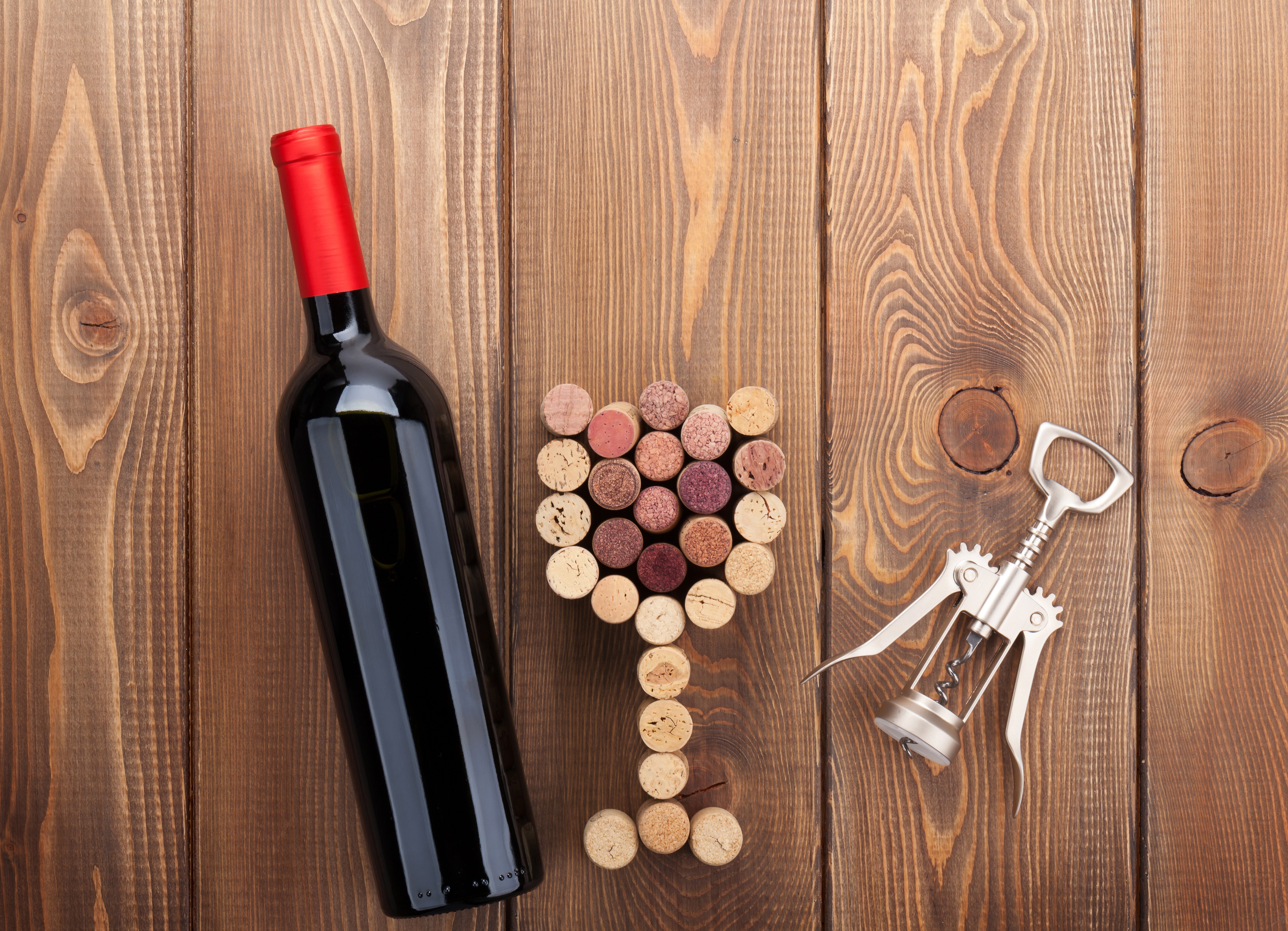 Wine bottle, corks, and corkscrew on wood HD Wallpaper