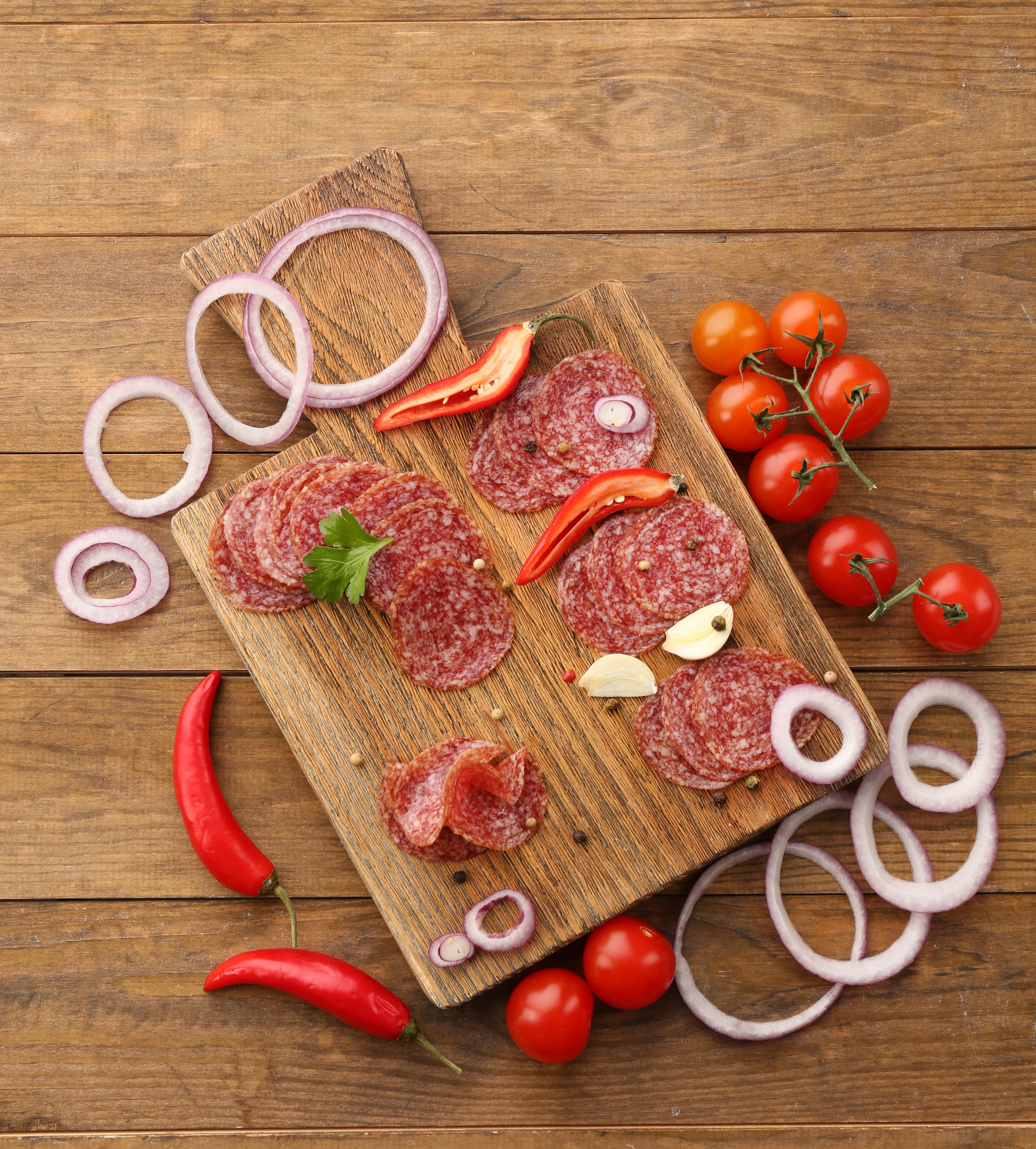 Sliced salami with tomatoes, onions, and peppers on cutting boards HD Wallpaper
