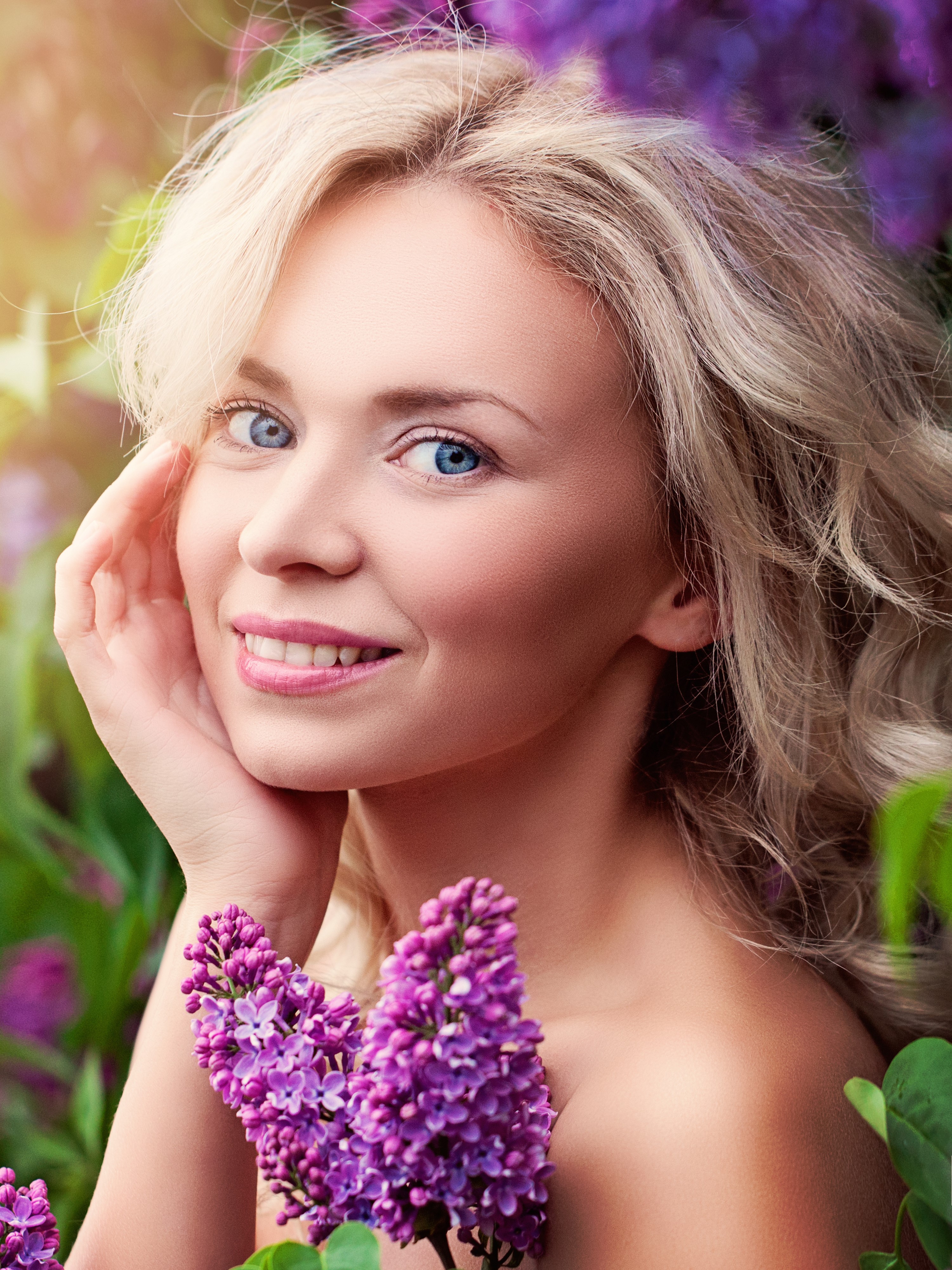 Blonde woman with blue eyes and lilac flowers HD Phone Wallpaper