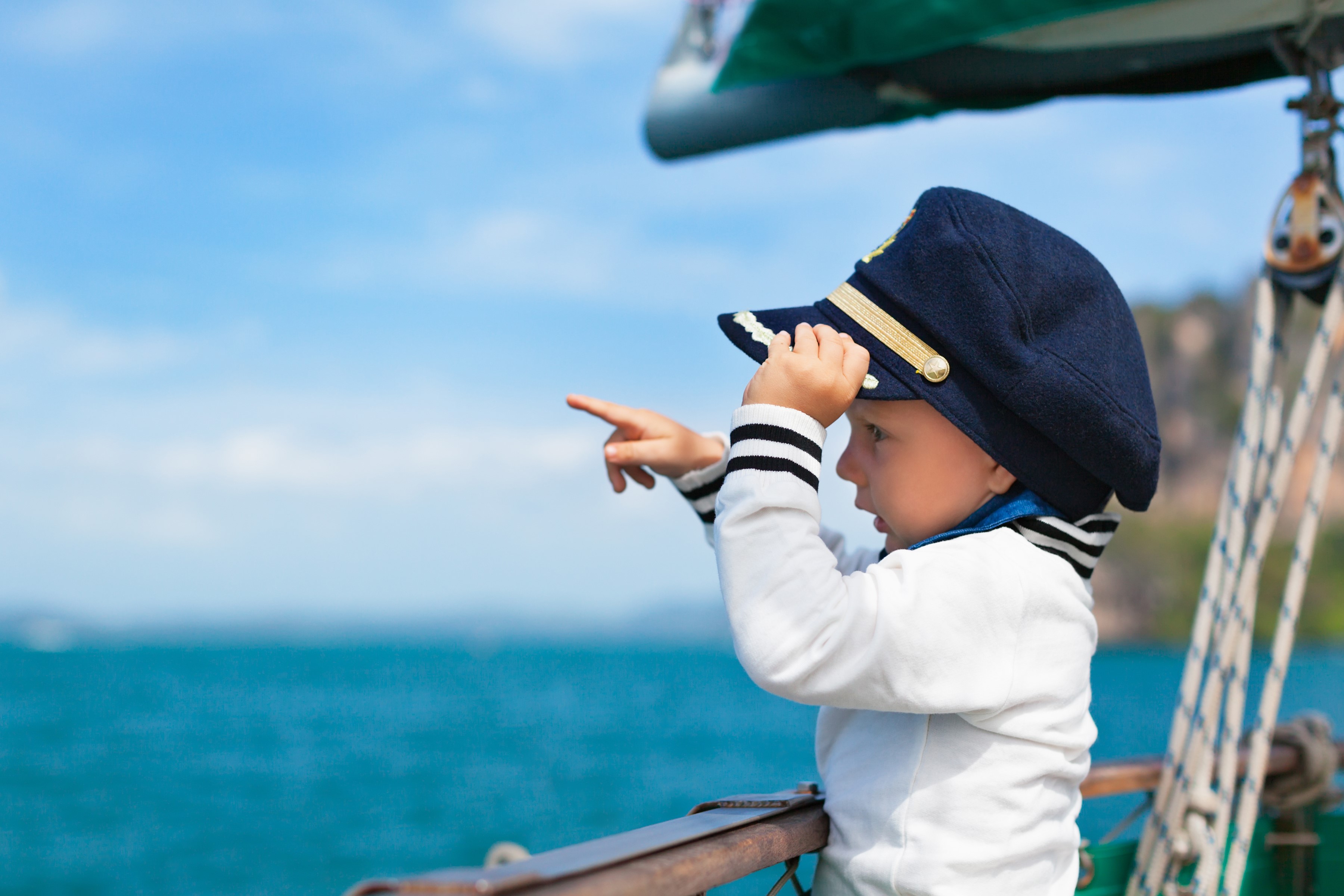 Boy in captain's hat on a sailboat HD Wallpaper