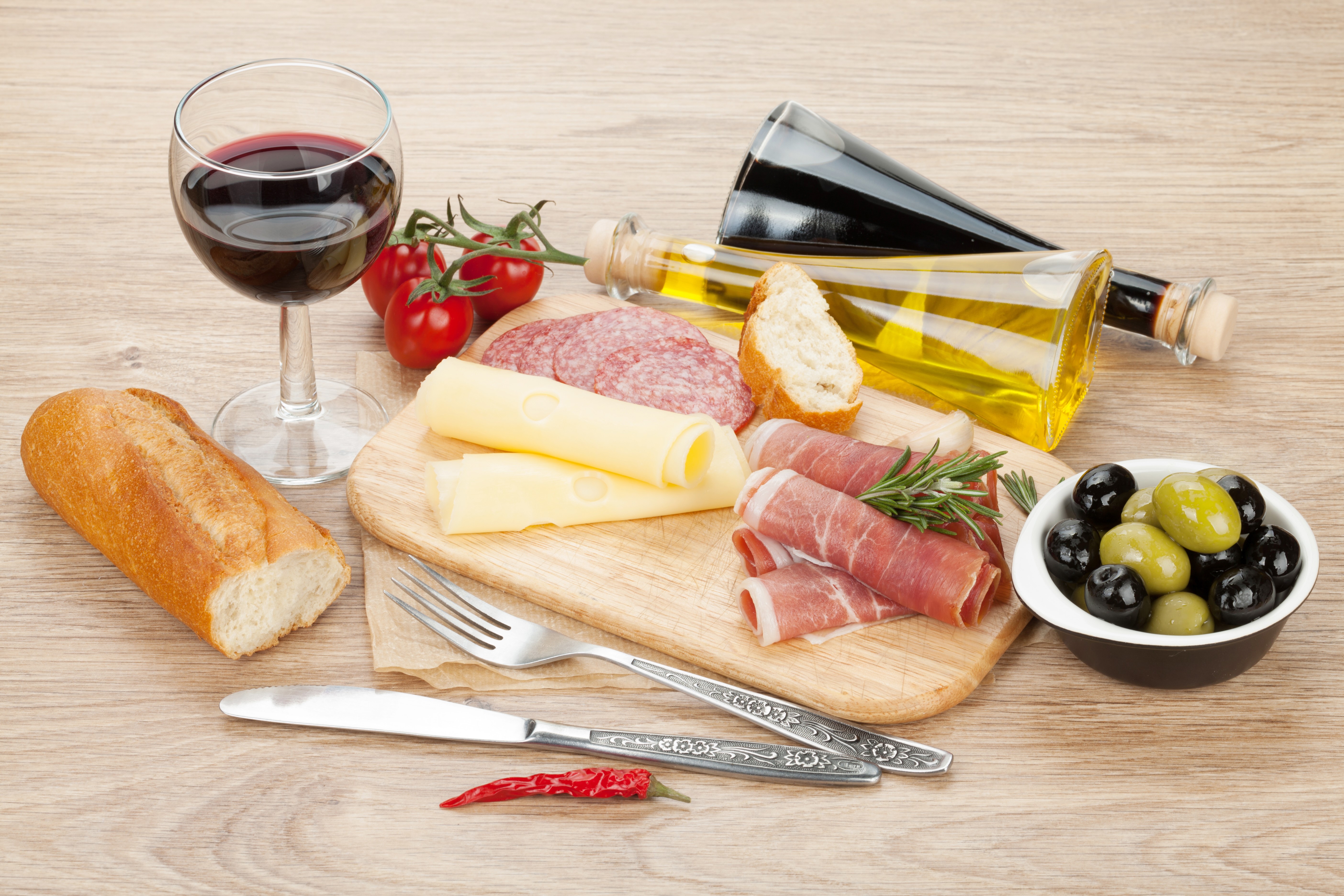 Still-life of wine, bread, cheese, ham, sausage, olives, and bottles HD Wallpaper