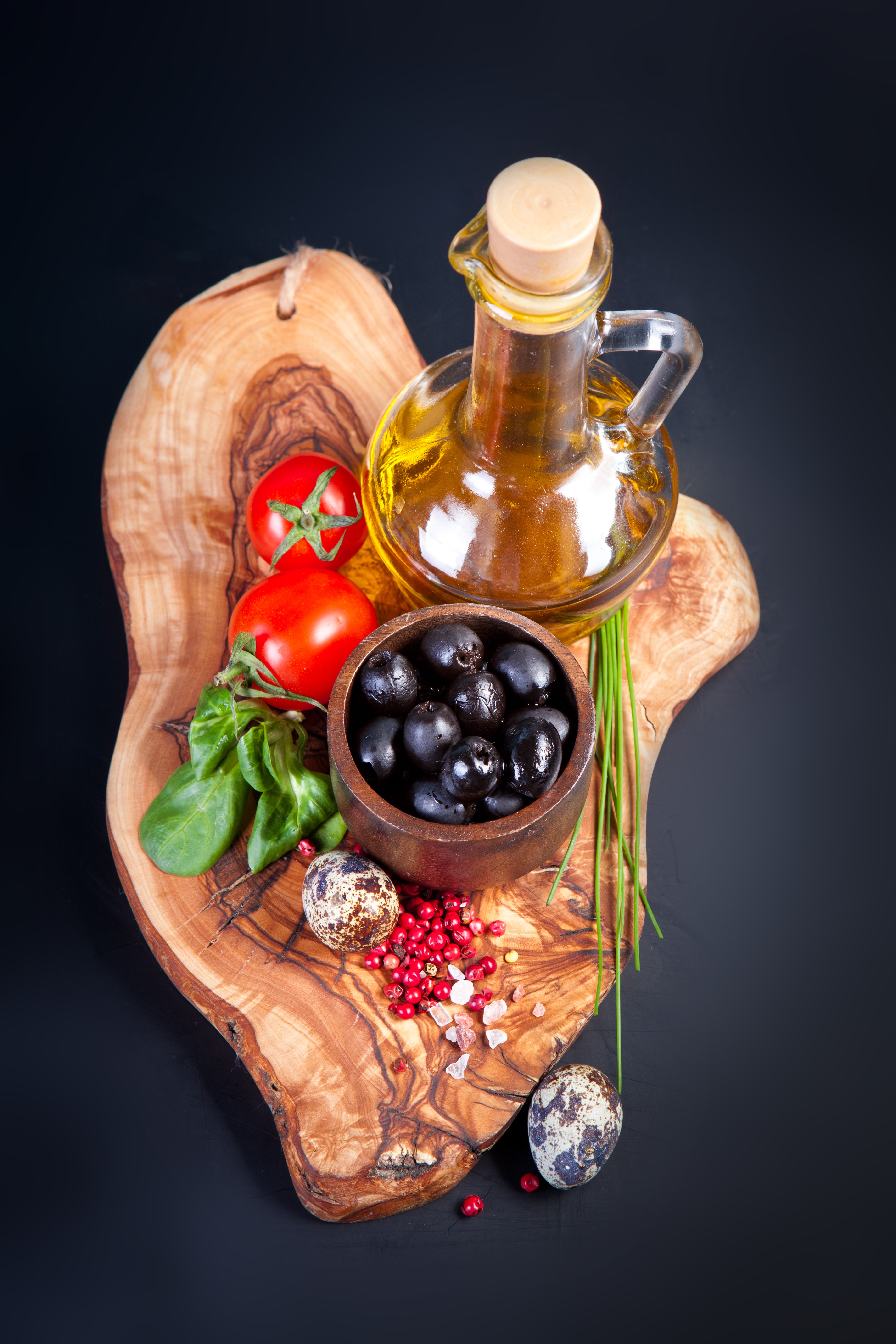 Olive oil, tomatoes, olives, quail eggs, and spices on a wooden board HD Phone Wallpaper