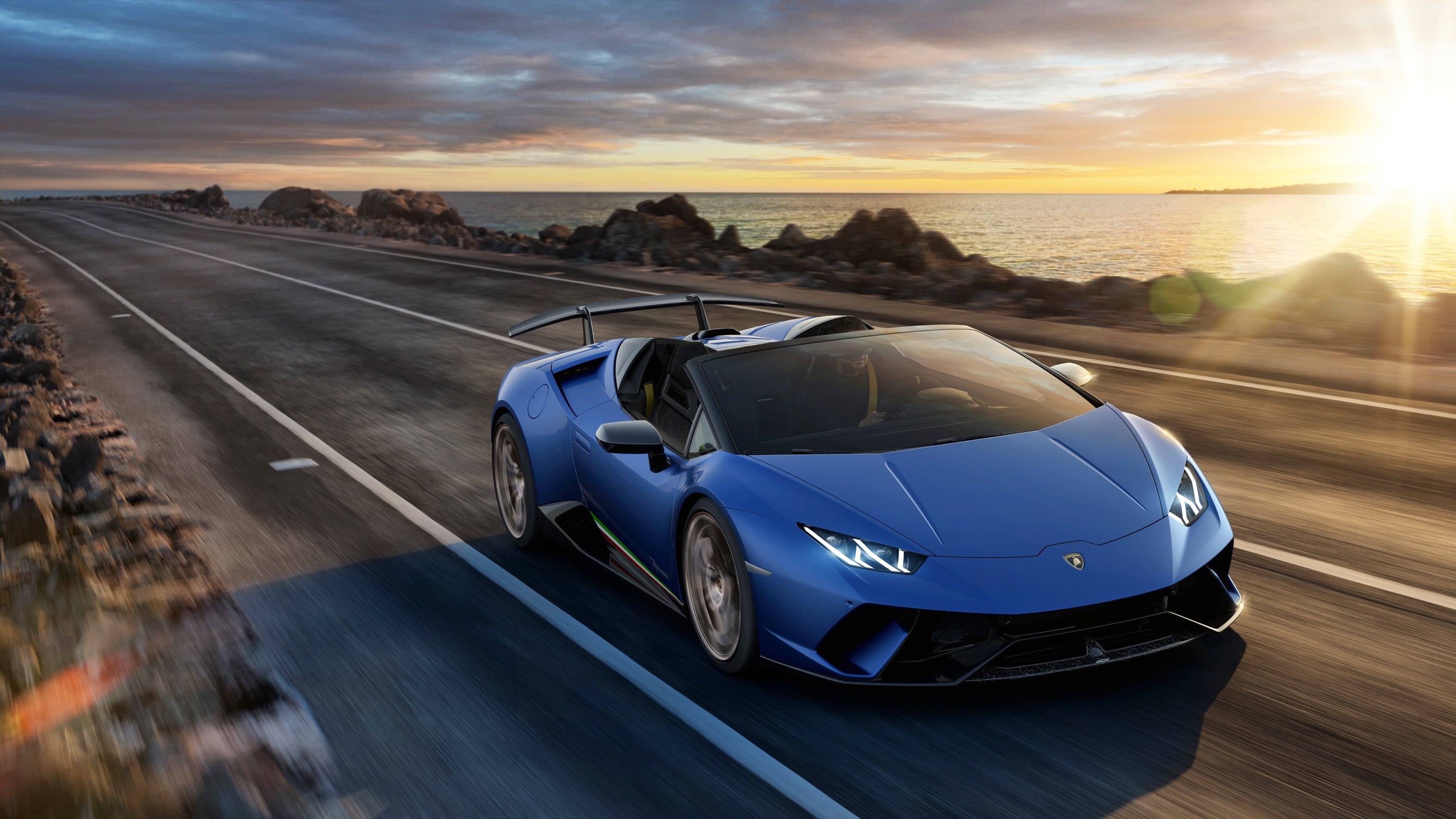 Blue Lamborghini Huracan Spyder driving on coastal road HD Wallpaper
