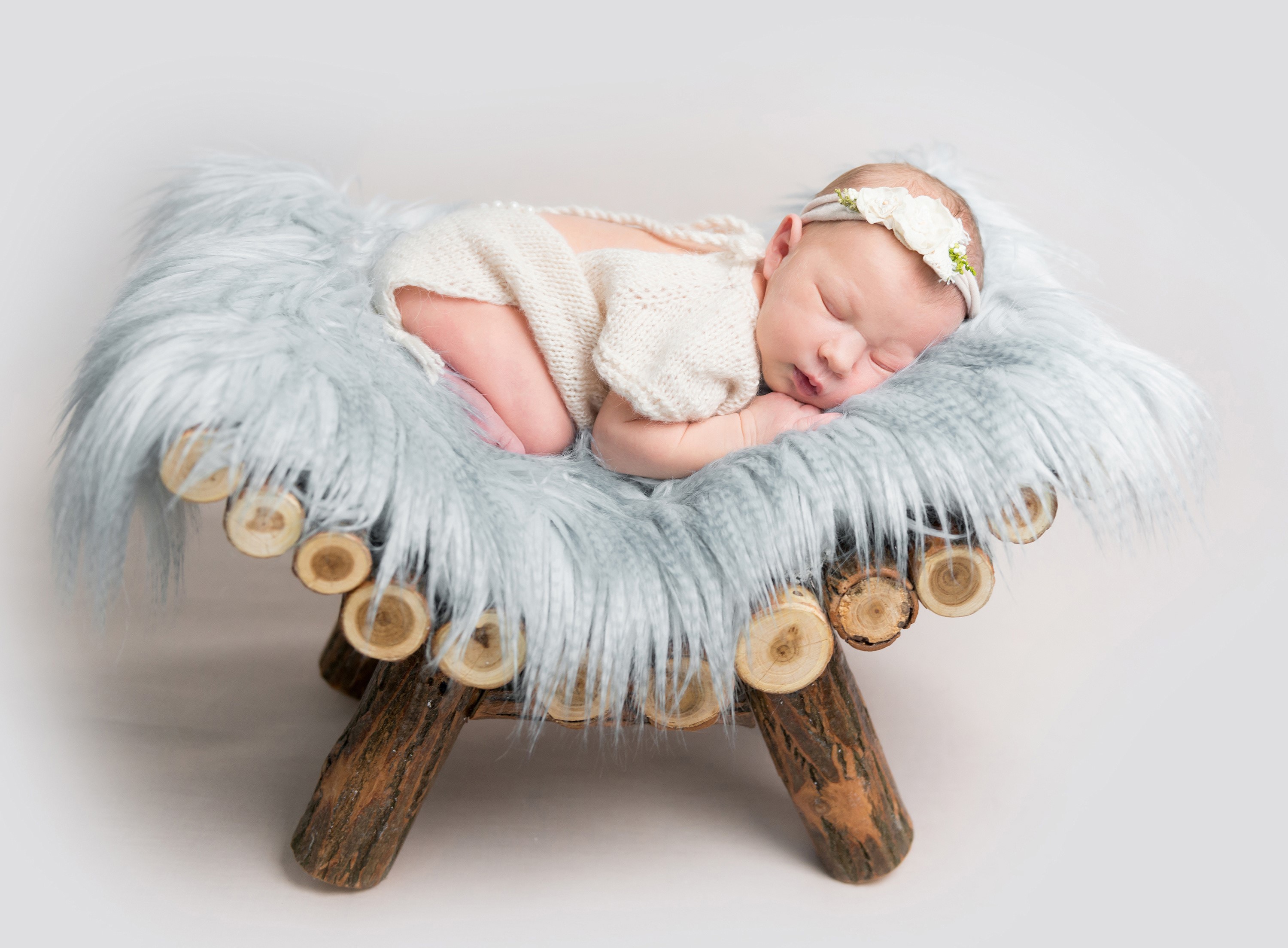 Newborn baby sleeping on a wooden prop HD Wallpaper