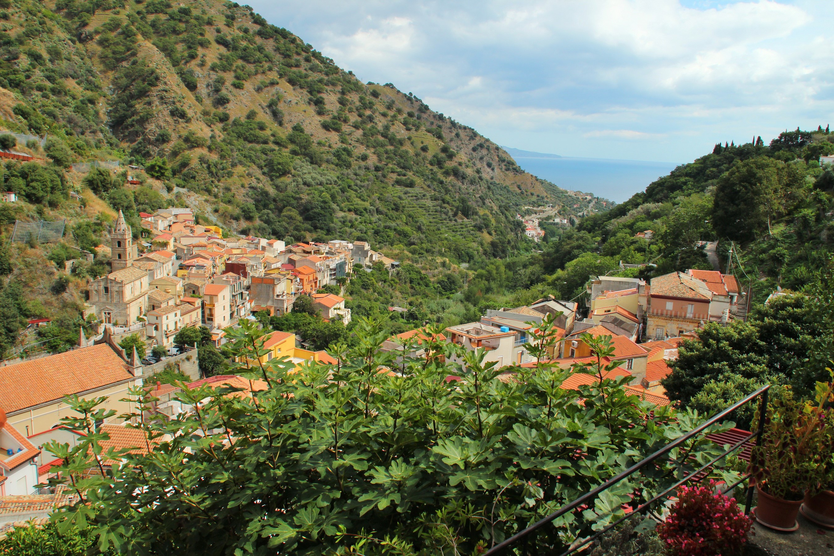 Village nestled in a Sicilian mountain valley overlooking the sea HD Wallpaper