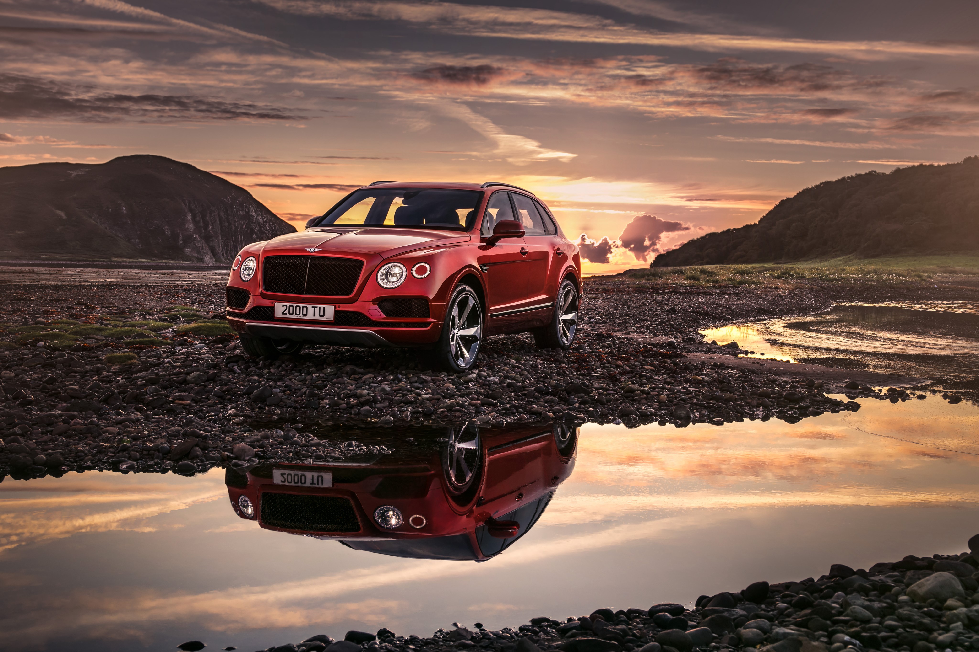 Red Bentley Bentayga V8 SUV on Rocky Shoreline HD Wallpaper