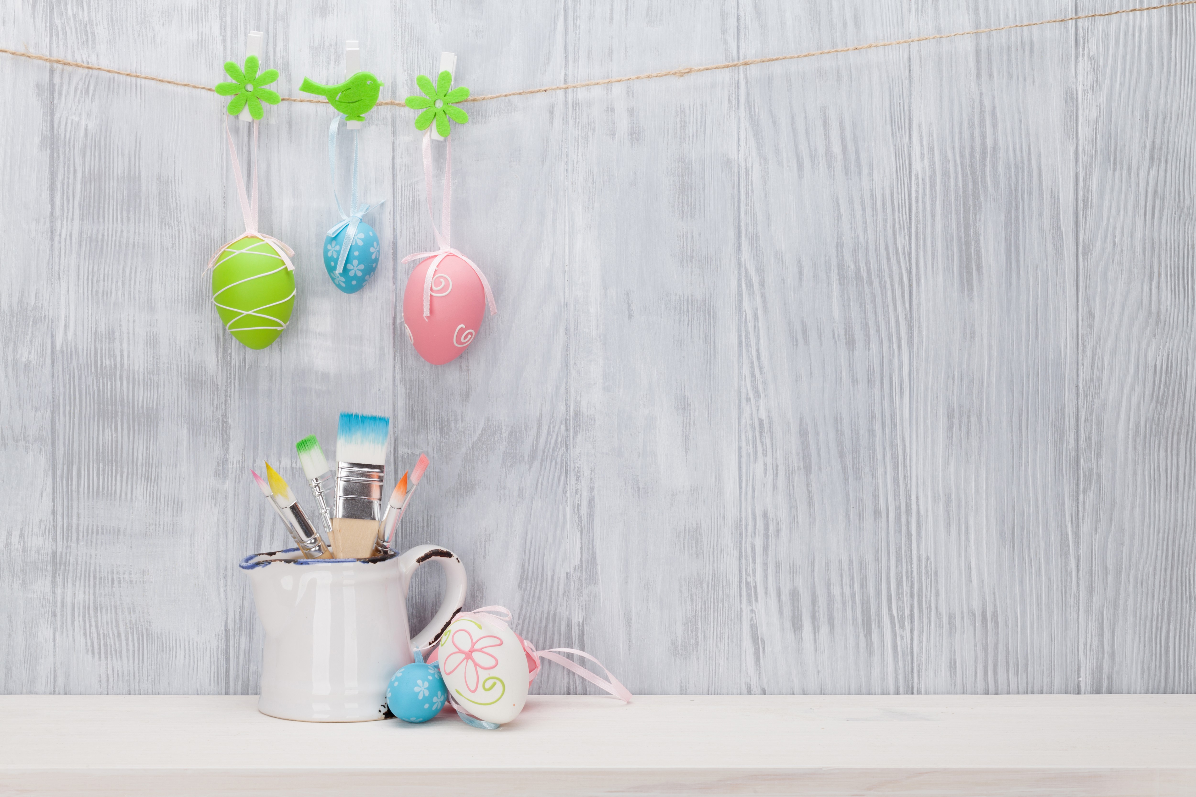 Easter eggs and paintbrushes on a wooden wall HD Wallpaper