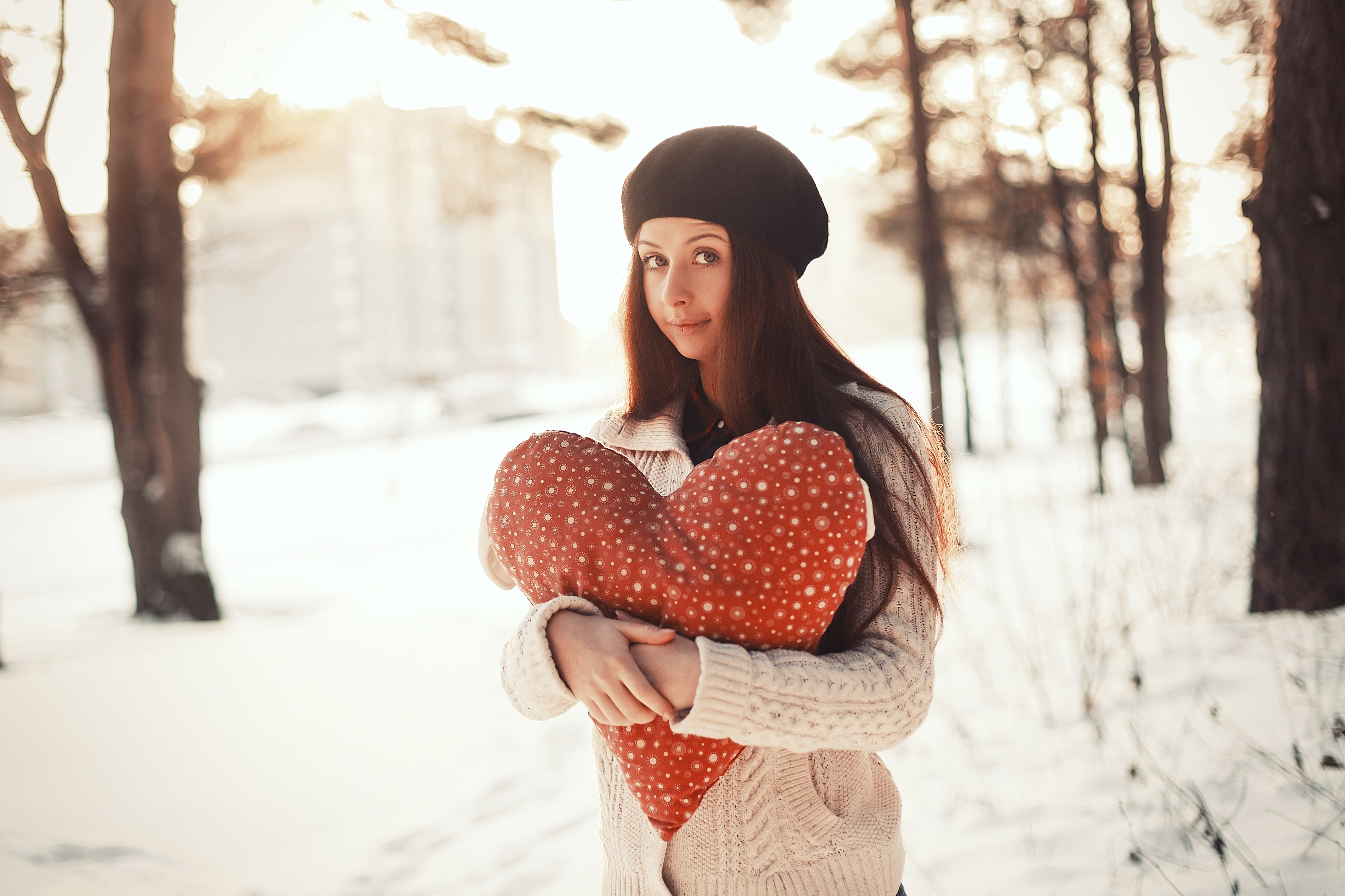 Woman holding a heart pillow in the snow HD Wallpaper