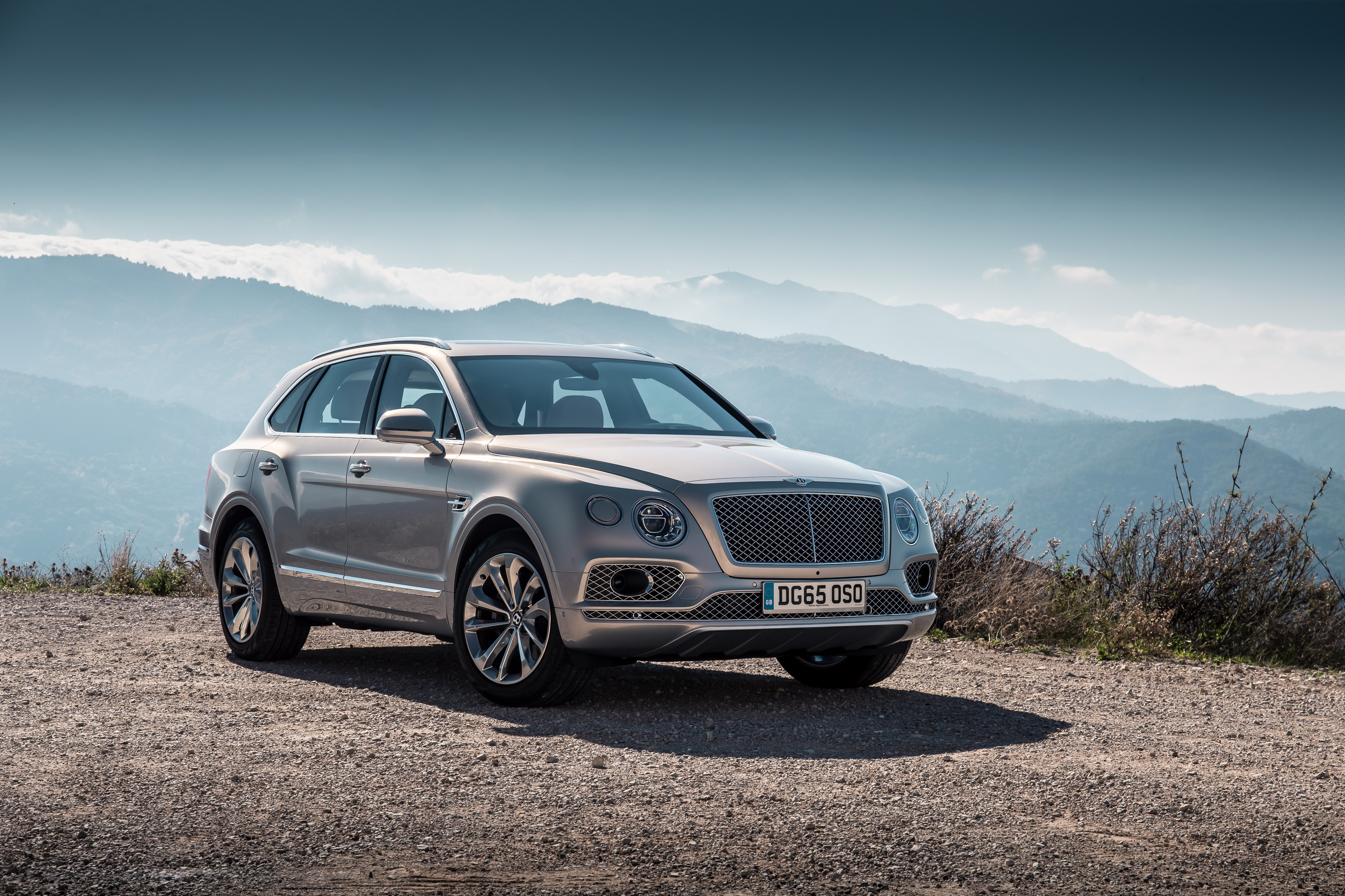 Bentley Bentayga SUV parked on a mountain road HD Wallpaper