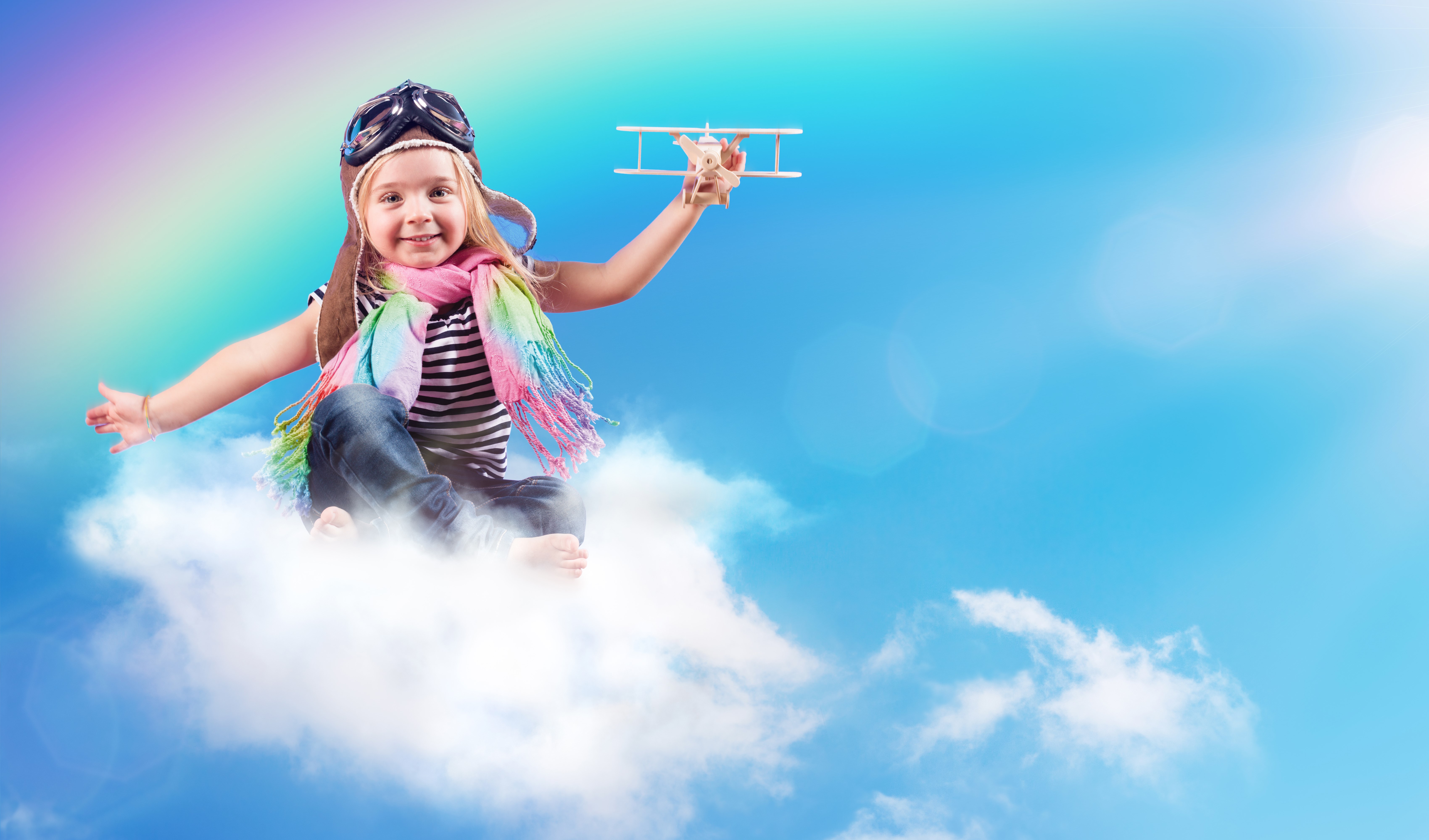 Girl in pilot hat with toy airplane on cloud HD Wallpaper