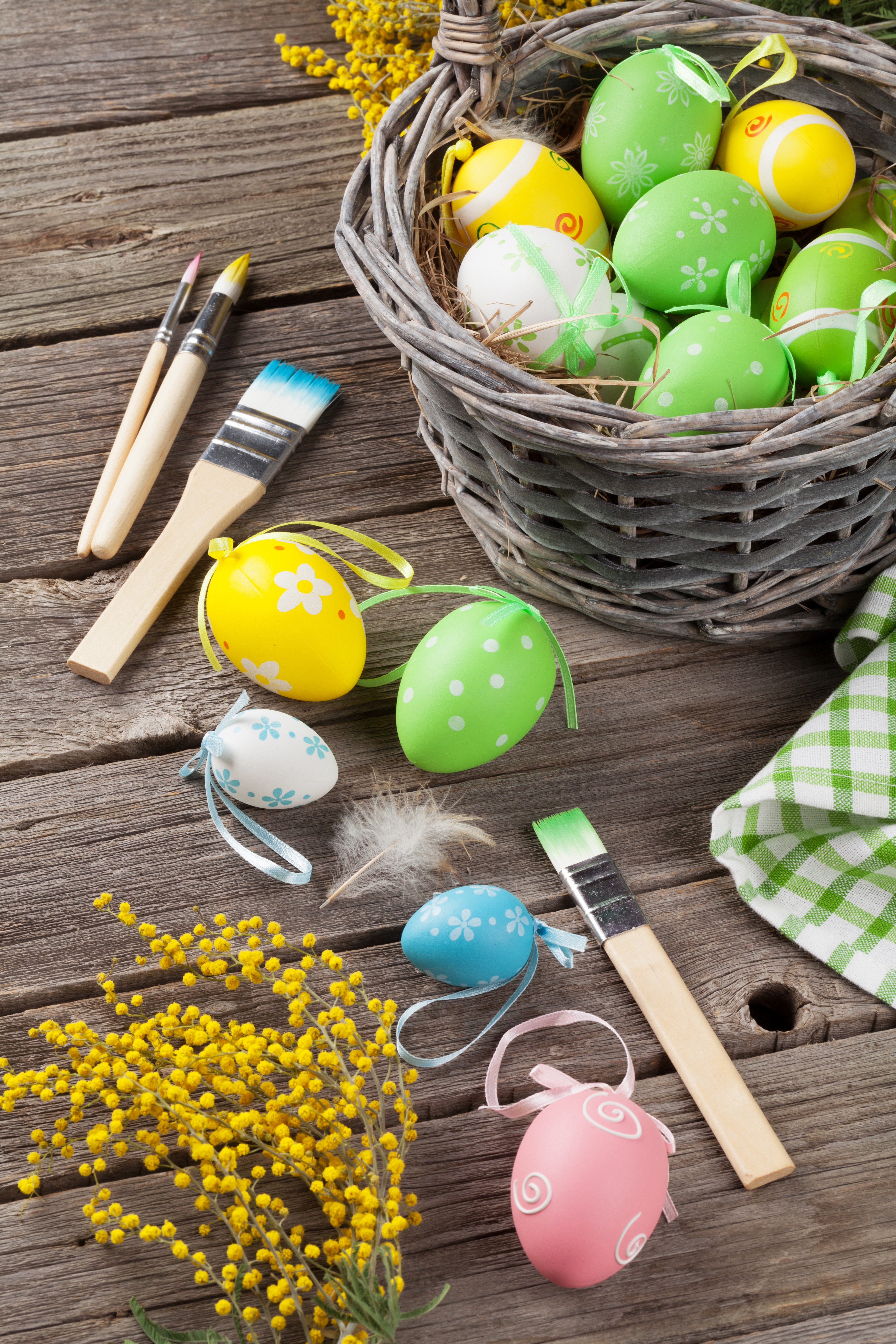 Easter eggs and paintbrushes on wooden planks with mimosa flowers HD Phone Wallpaper