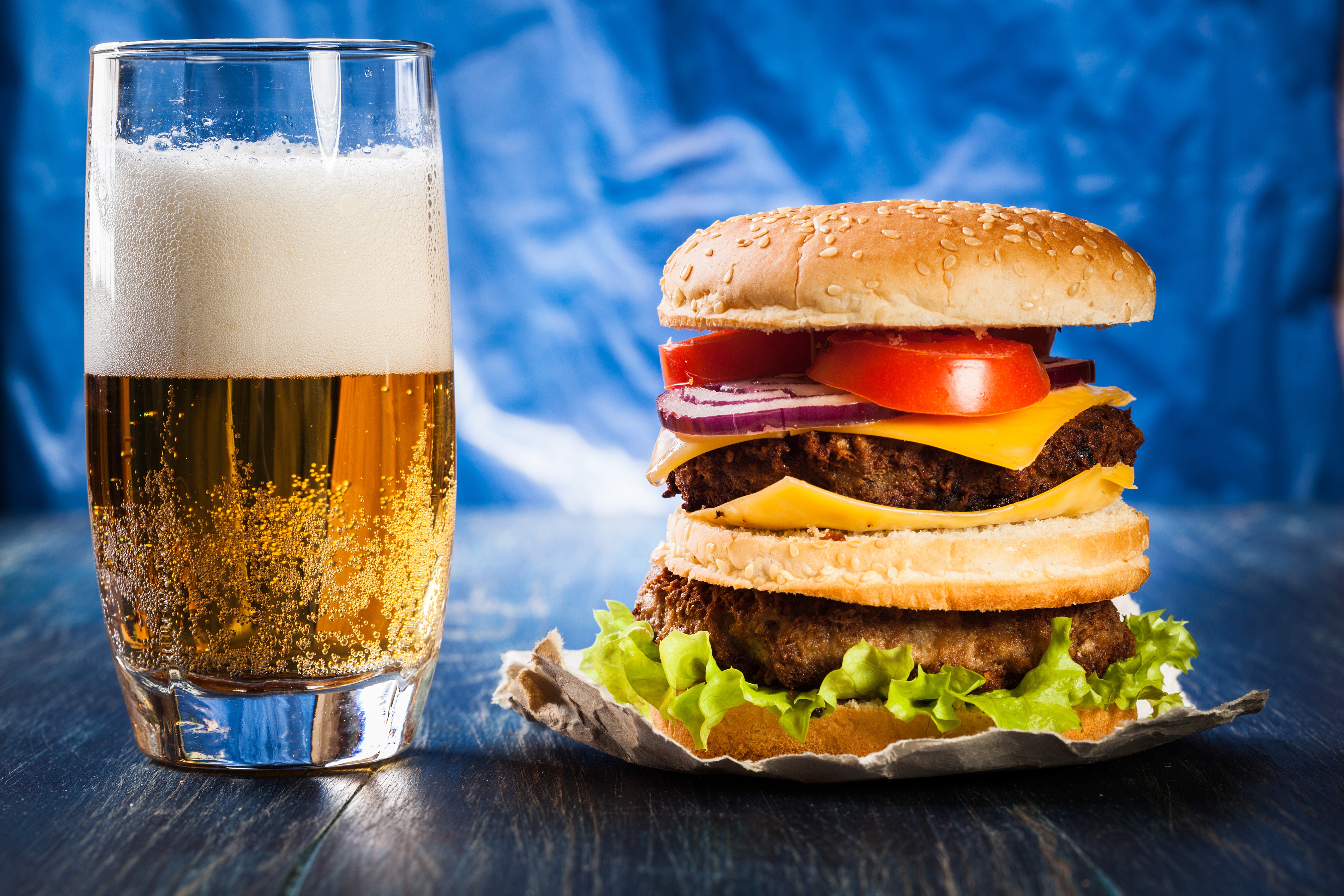 Beer and a double hamburger with lettuce, tomato, onion, and cheese HD Wallpaper