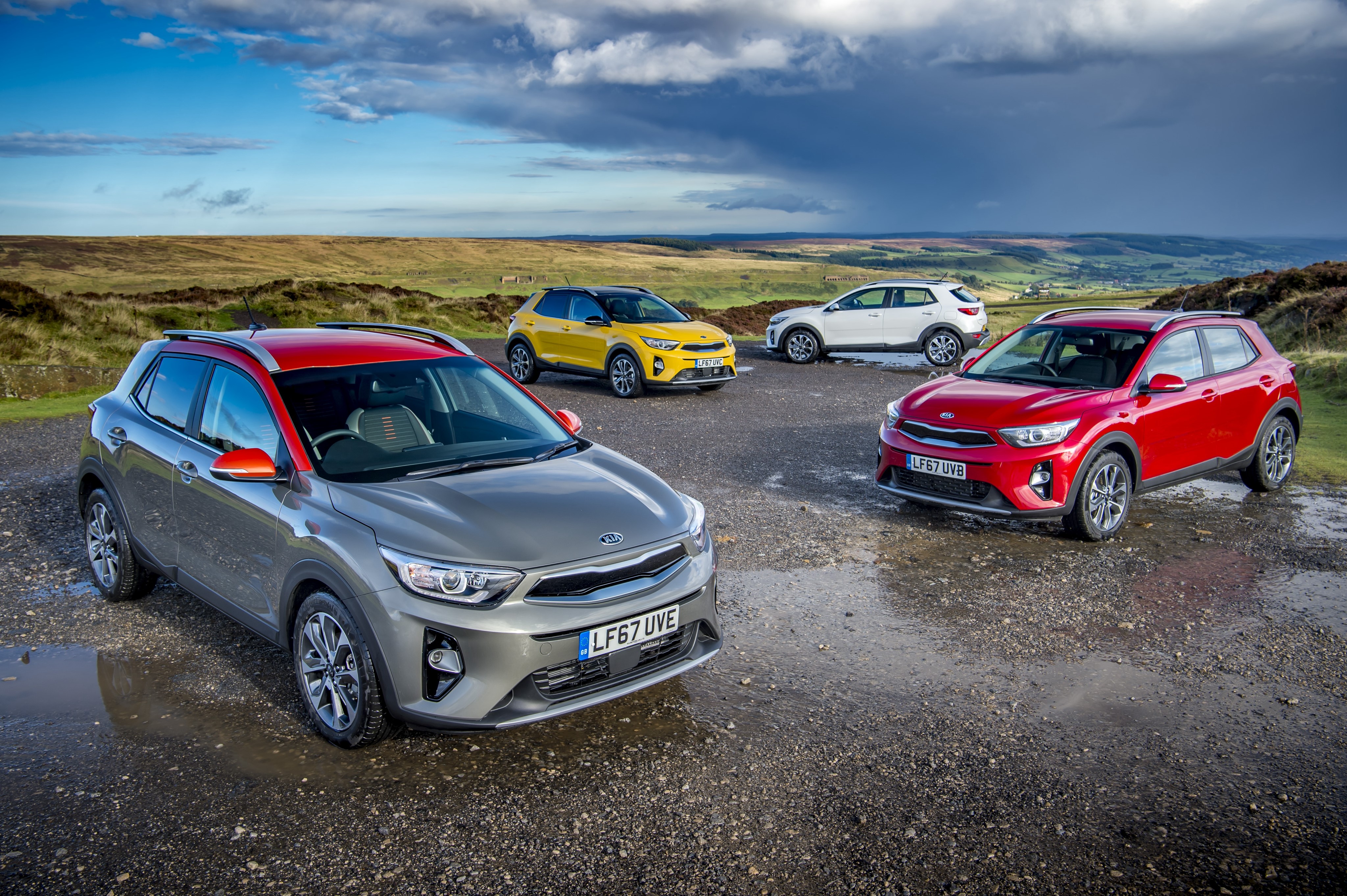4 Kia Stonic cars in a landscape HD Wallpaper