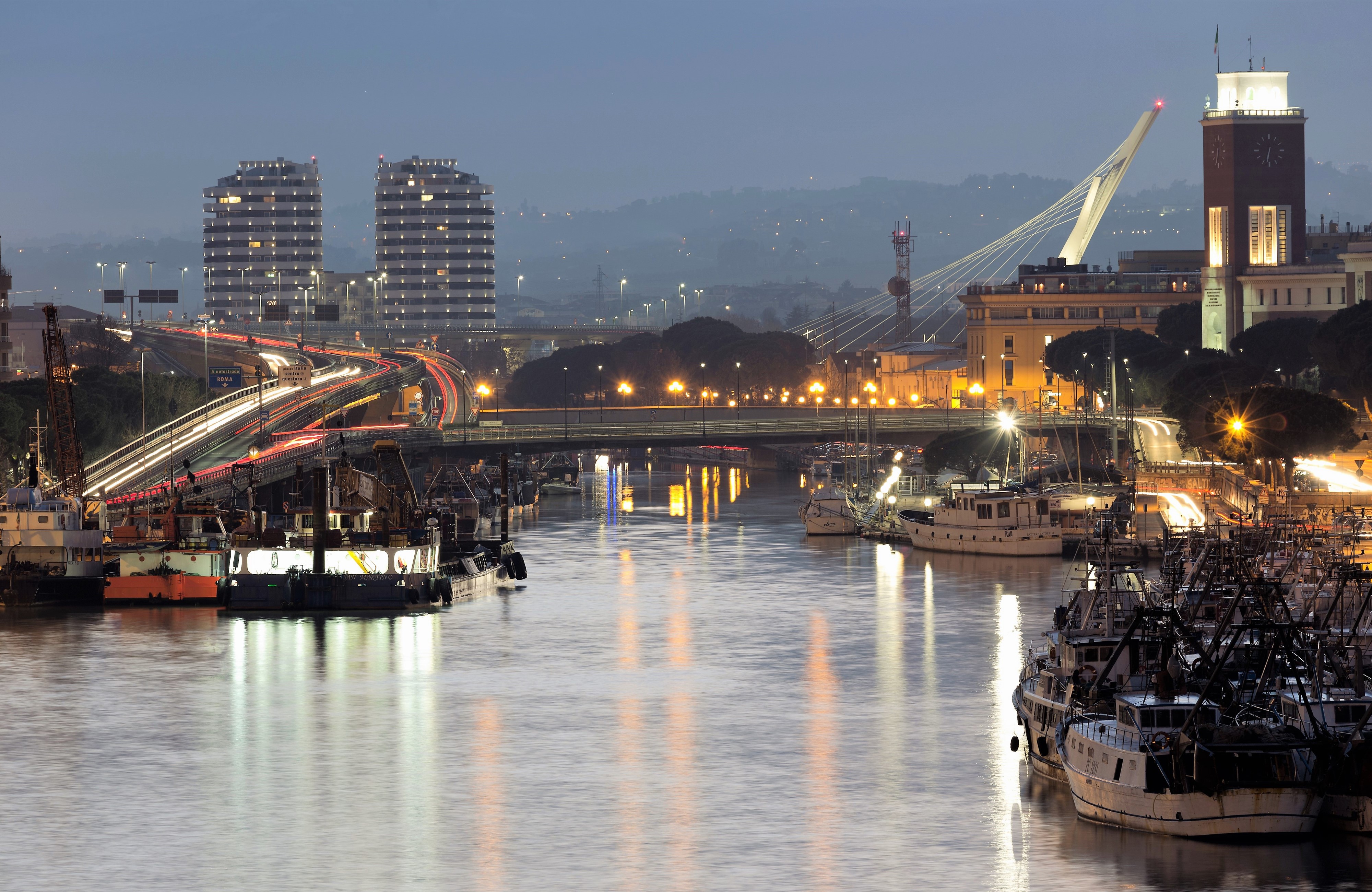 Evening view of a river with boats and bridges in Italy HD Wallpaper
