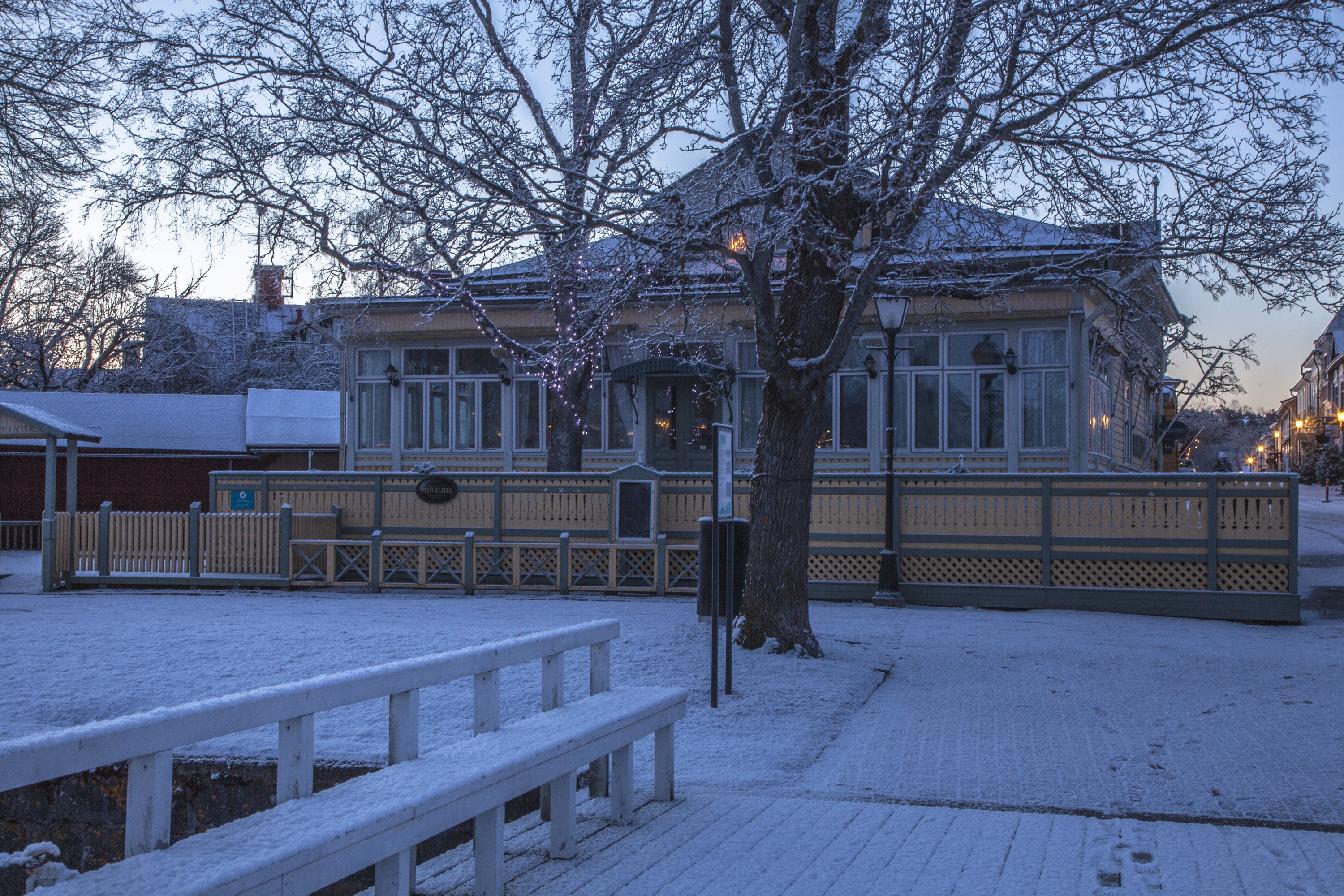 Snowy winter scene in Naantali, Finland with a wooden house and fence HD Wallpaper