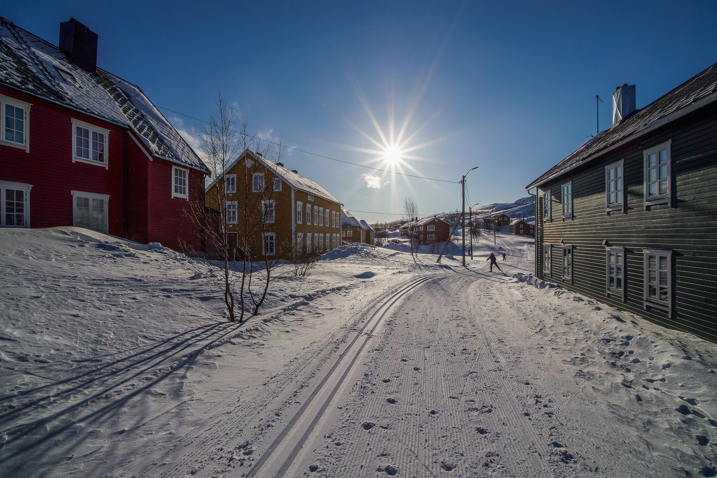 Winter scene in Sulitjelma, Norway with houses and skiers HD Wallpaper
