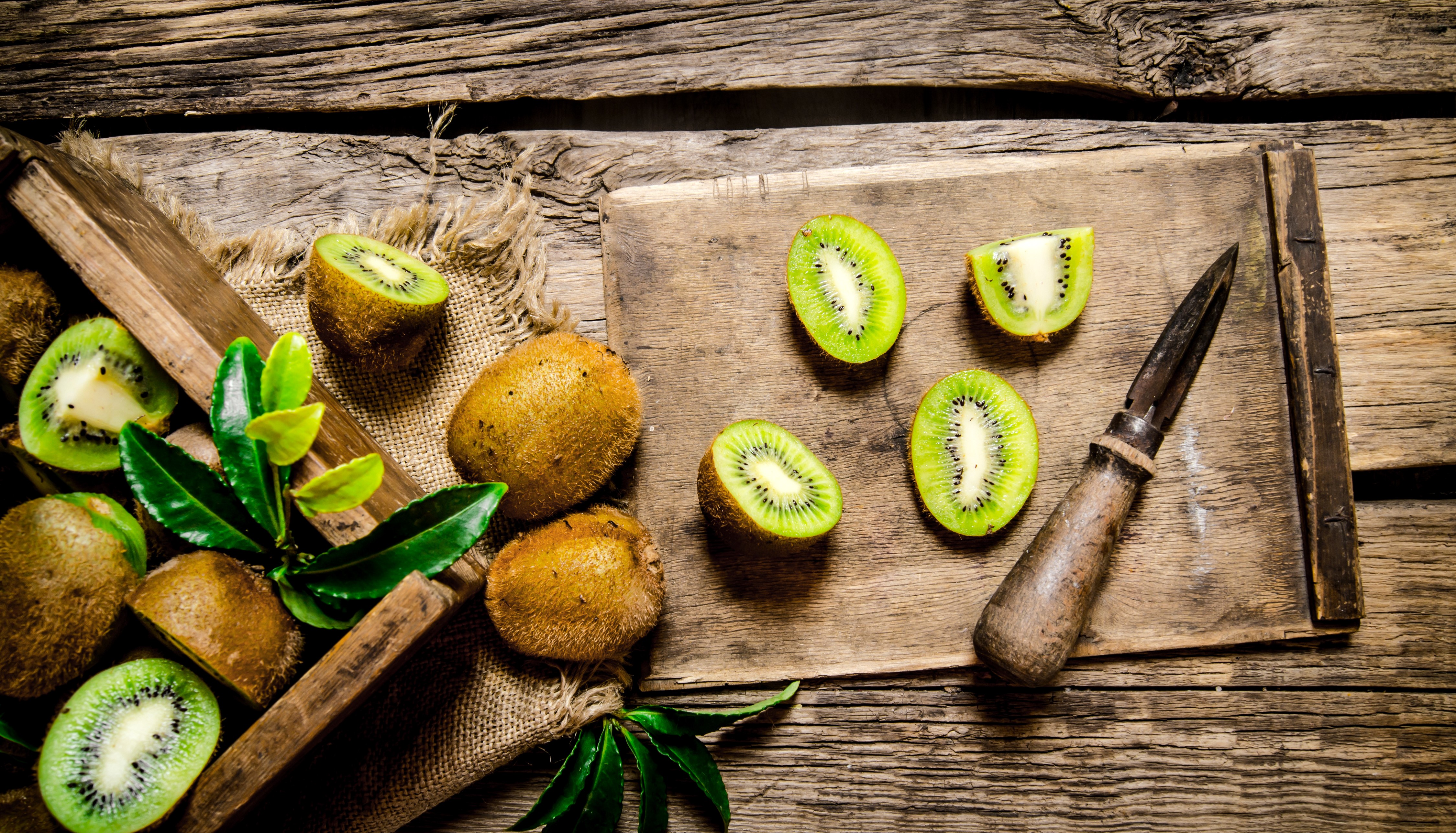 Kiwi fruit on wooden planks with knife HD Wallpaper