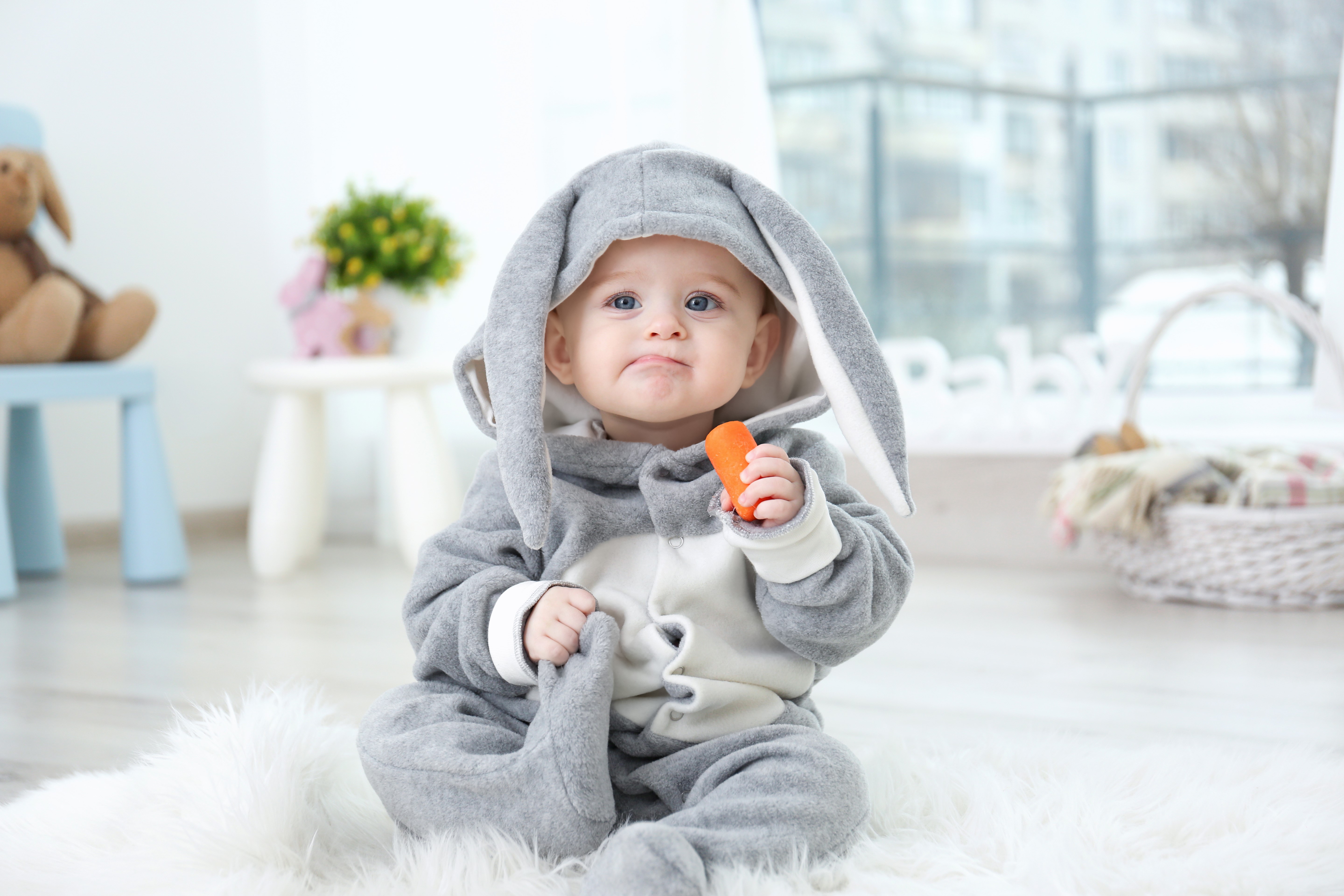 Baby in a bunny costume holding a carrot HD Wallpaper