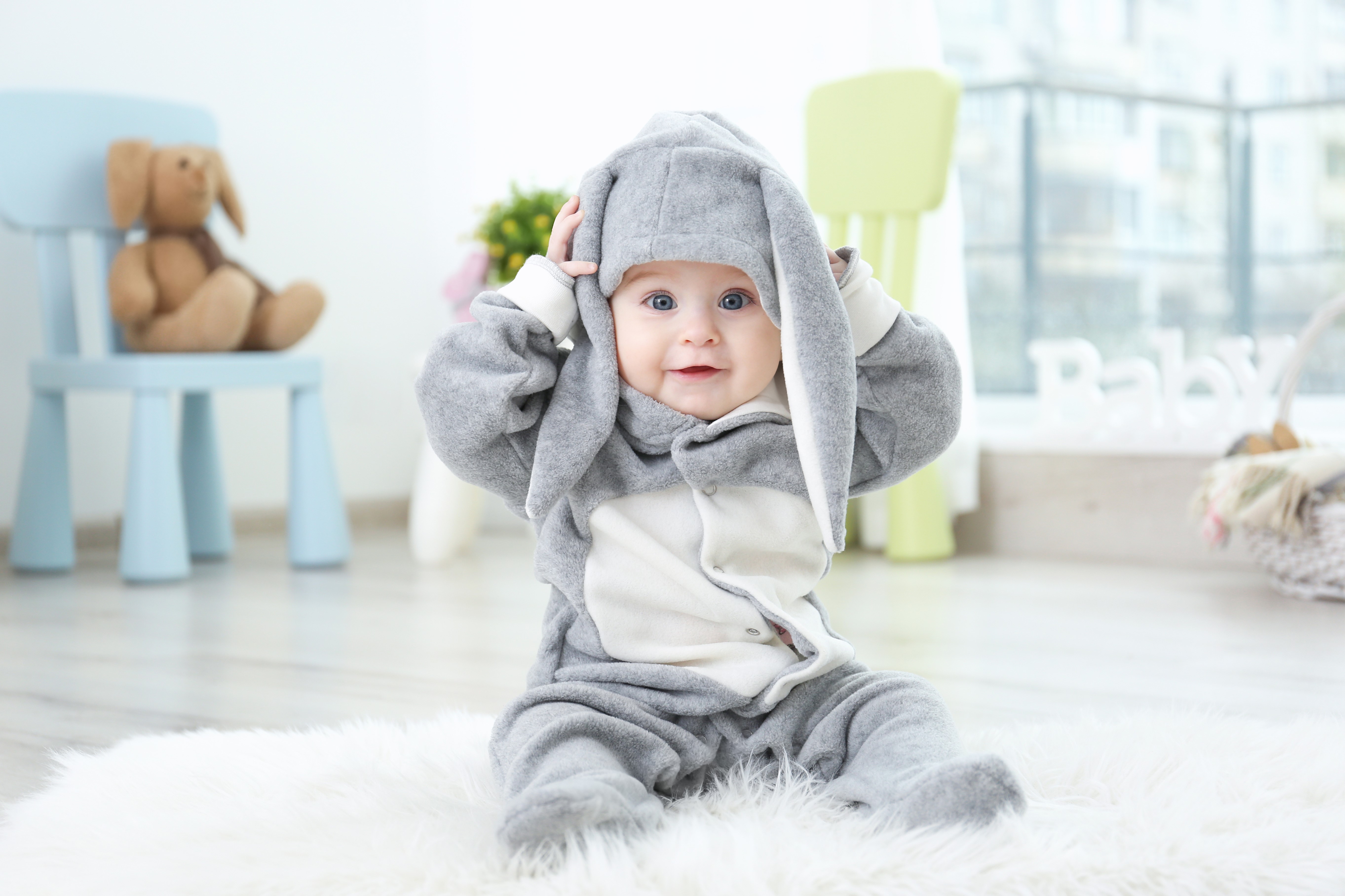 Baby in a bunny costume sitting on a rug HD Wallpaper