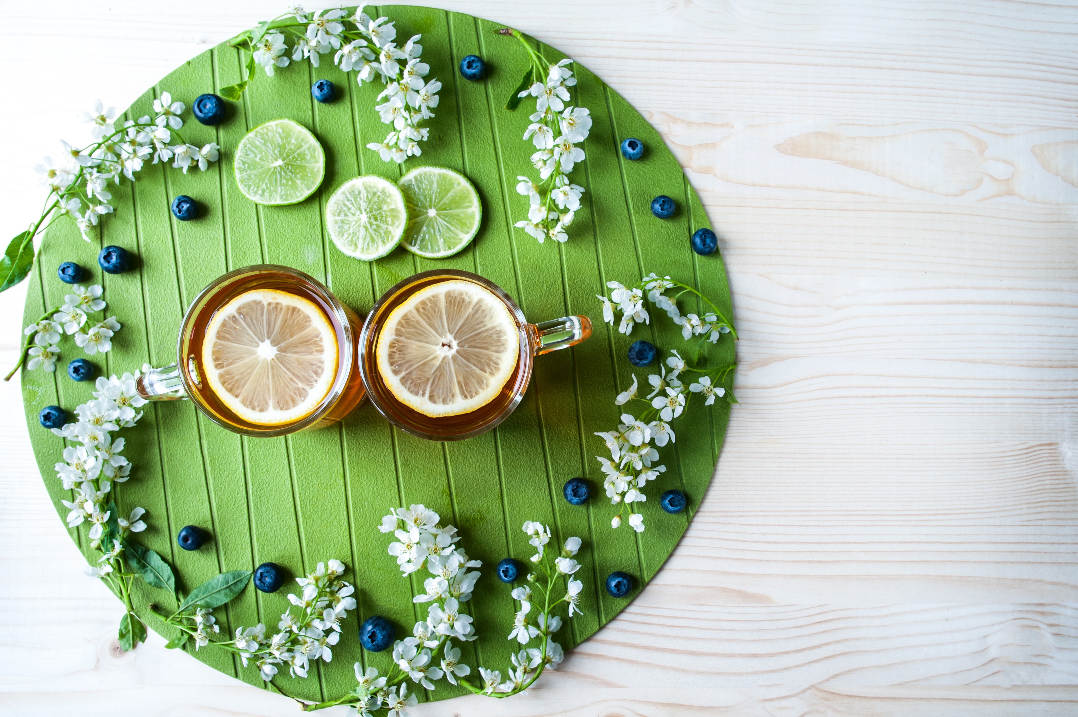 Two cups of tea with lemon slices, blueberries, and white flowers HD Wallpaper
