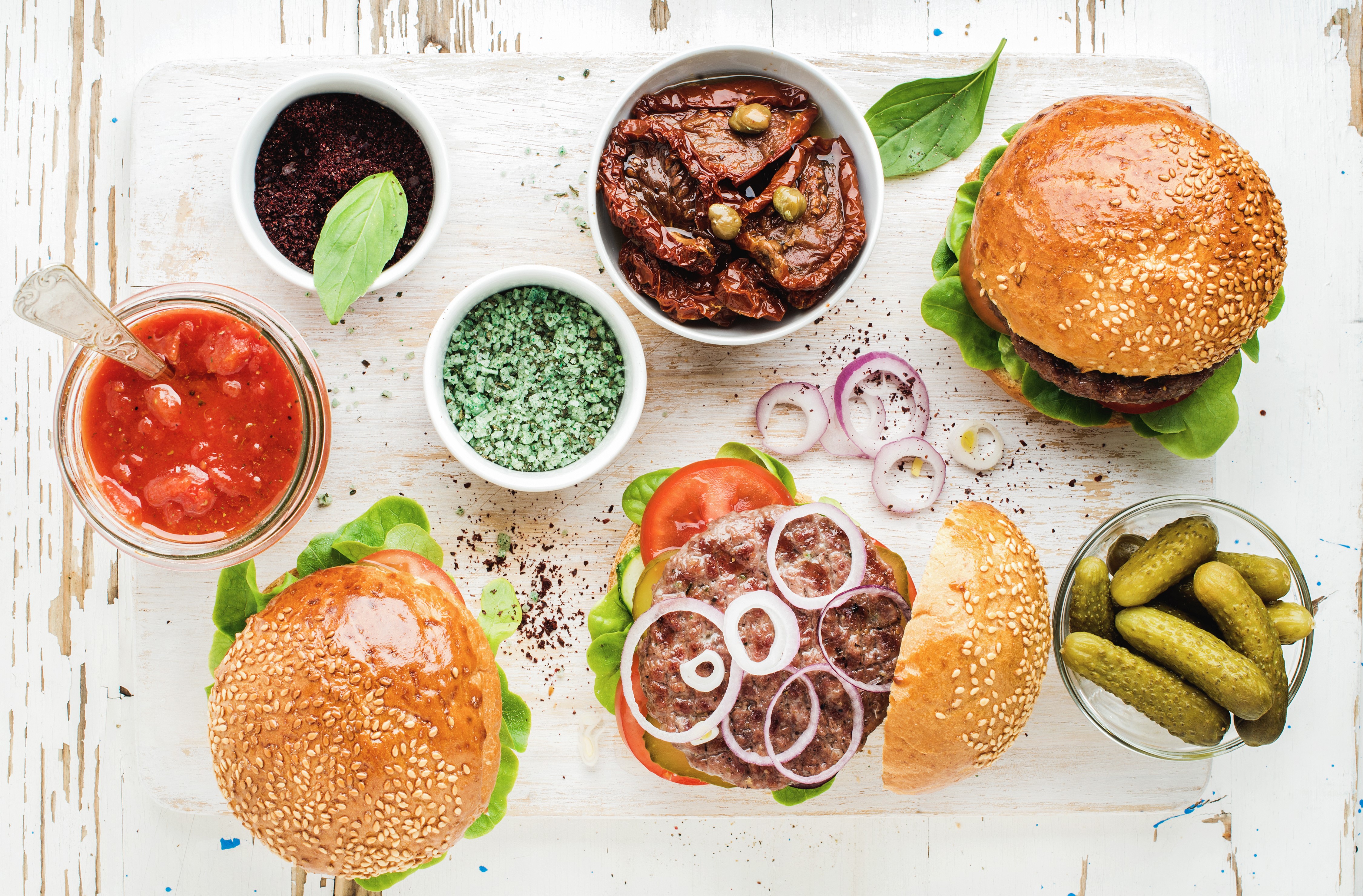 Hamburger ingredients with pickles and sauces HD Wallpaper