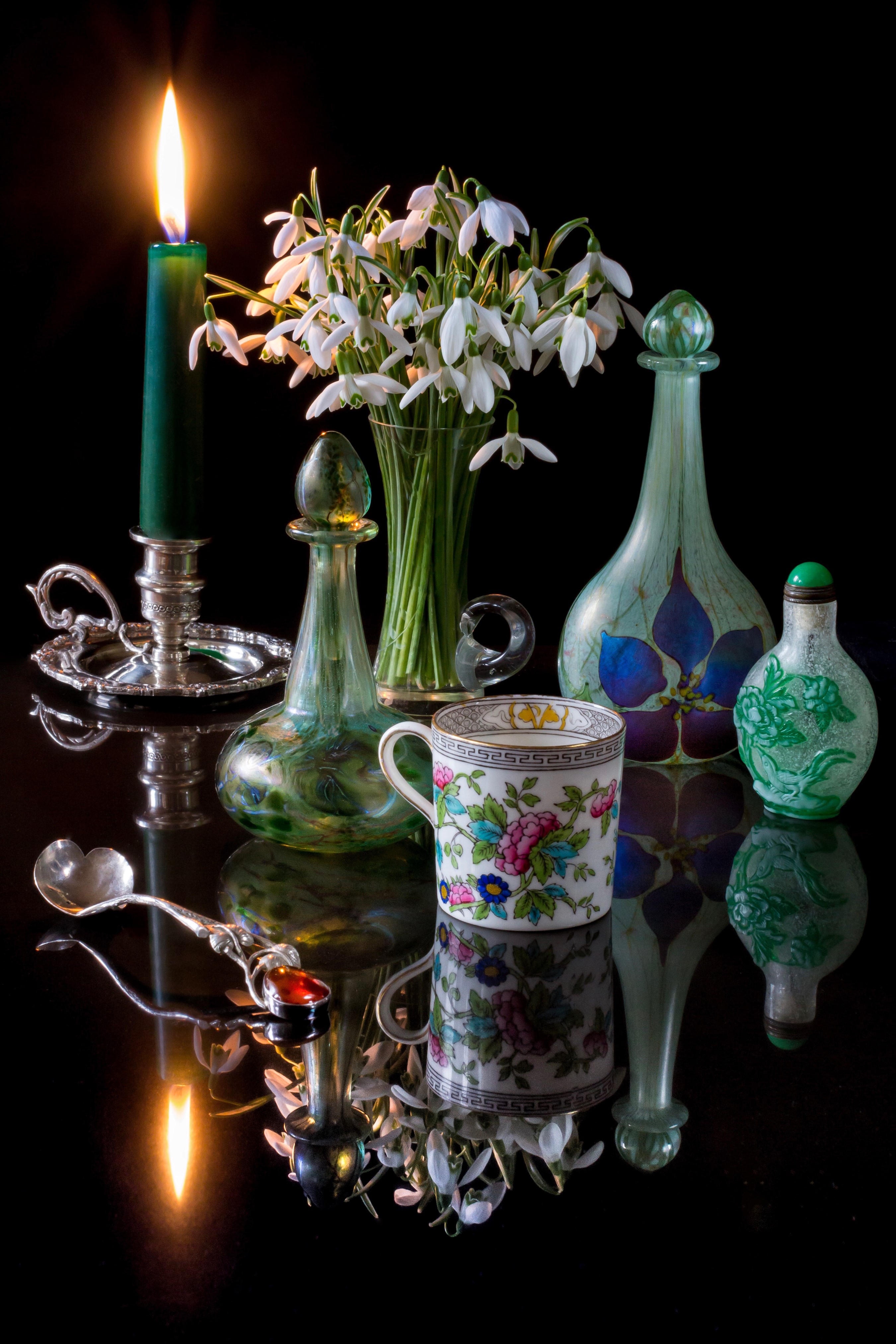 Still-life with snowdrops, candle, cup, and bottles HD Phone Wallpaper