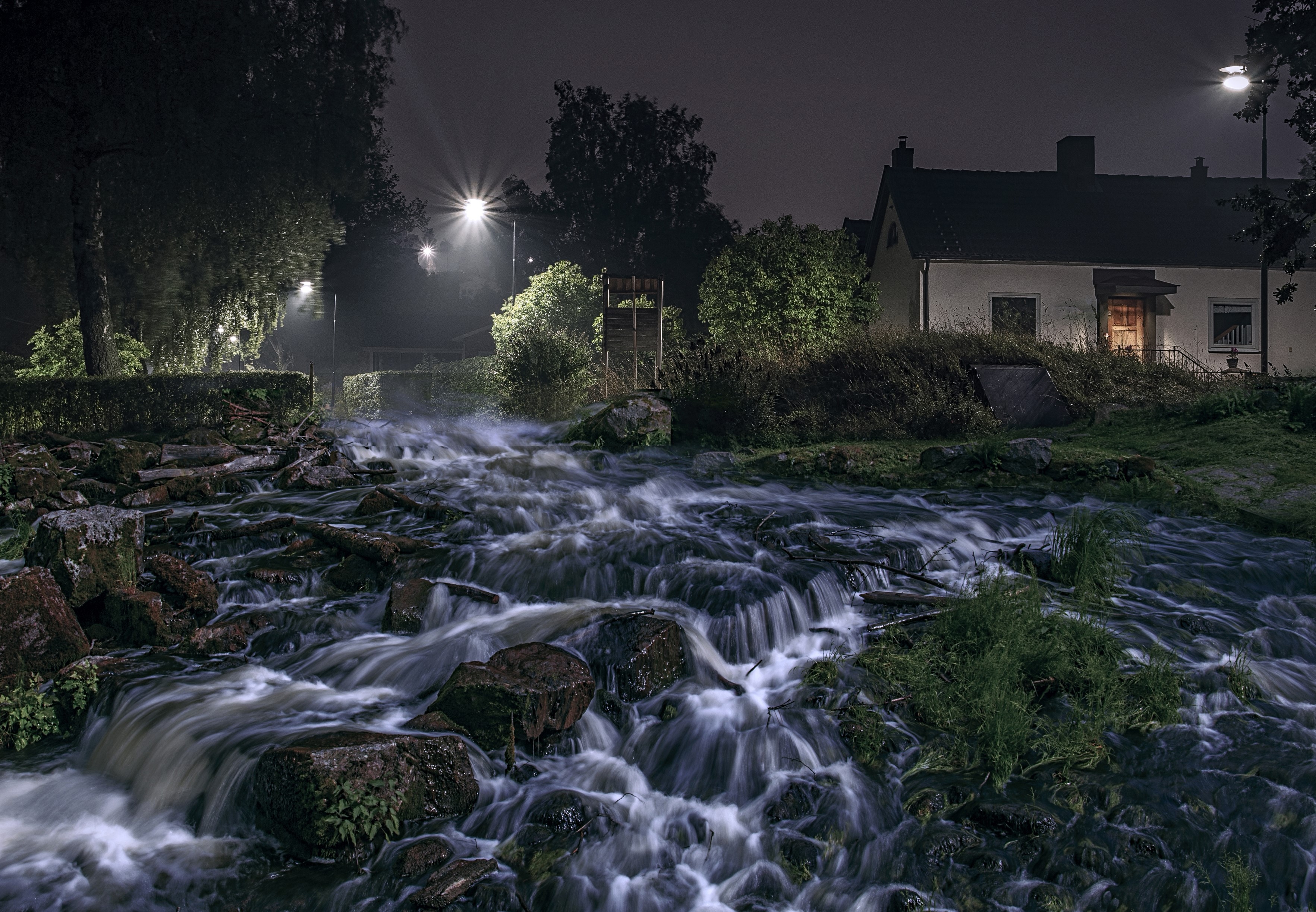Night scene of a river flowing past houses in Sweden HD Wallpaper