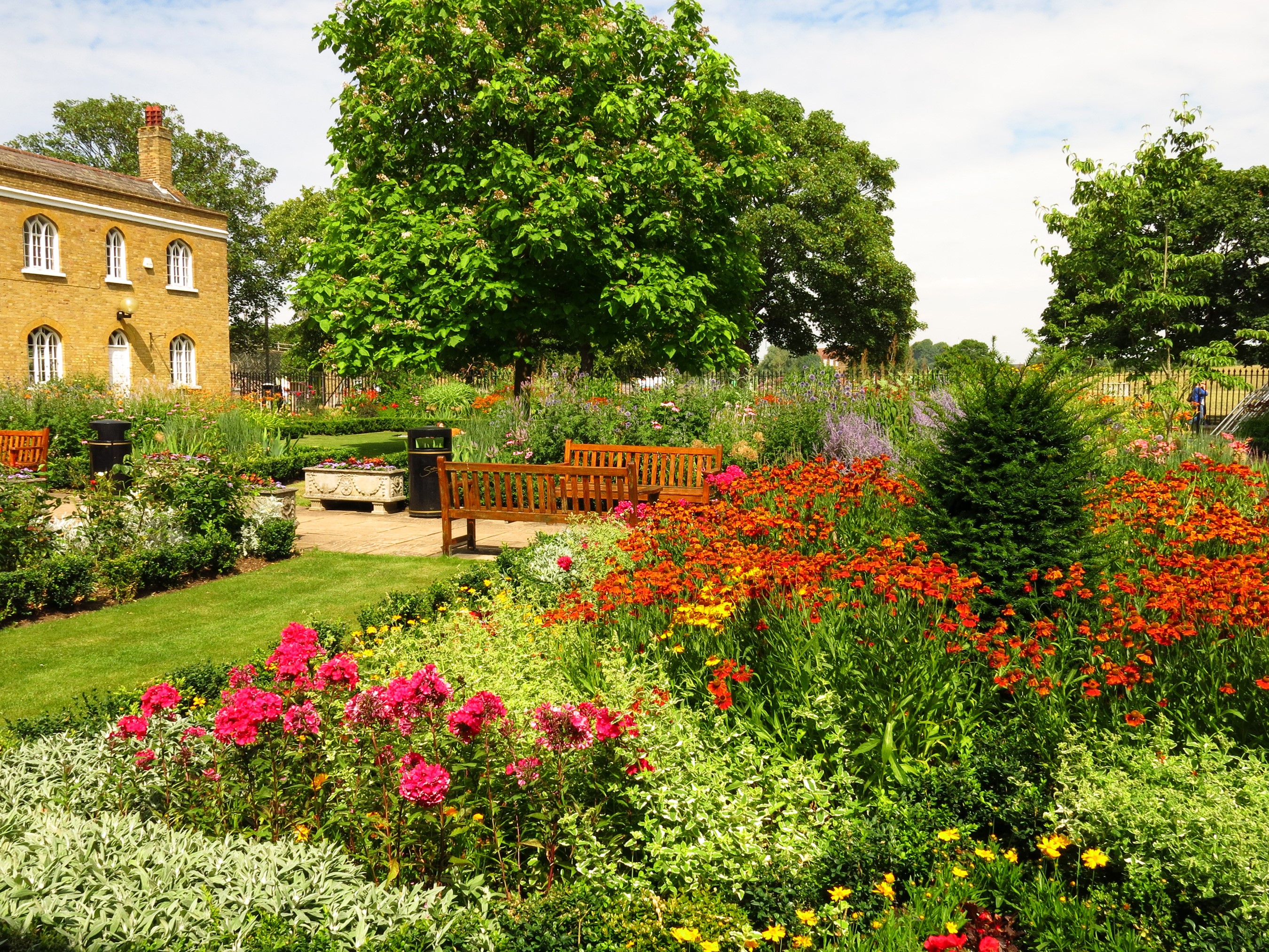 Chumleigh Gardens Burgess Park with flowers and building HD Wallpaper