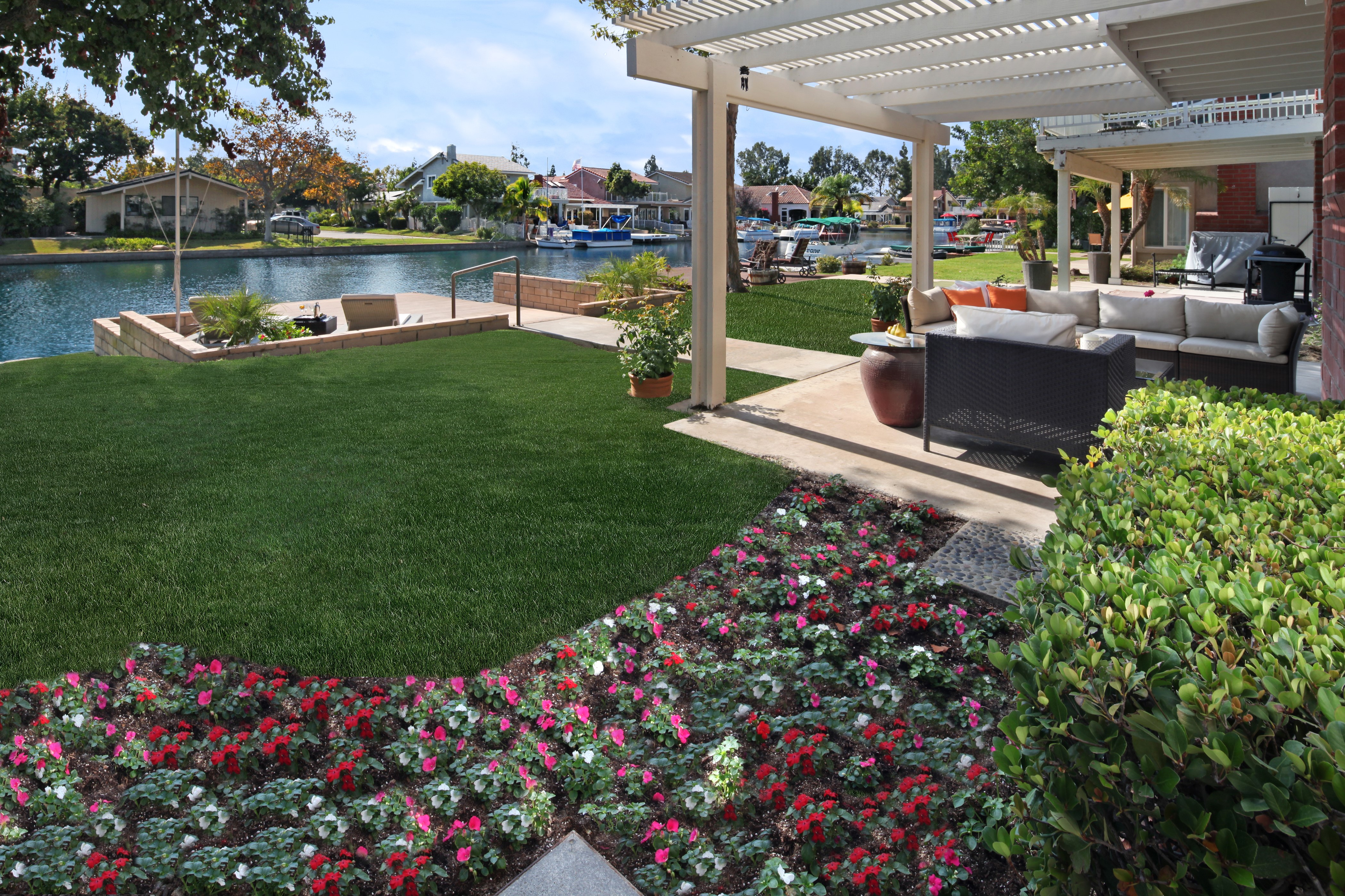 Backyard patio with canal view and flowers HD Wallpaper