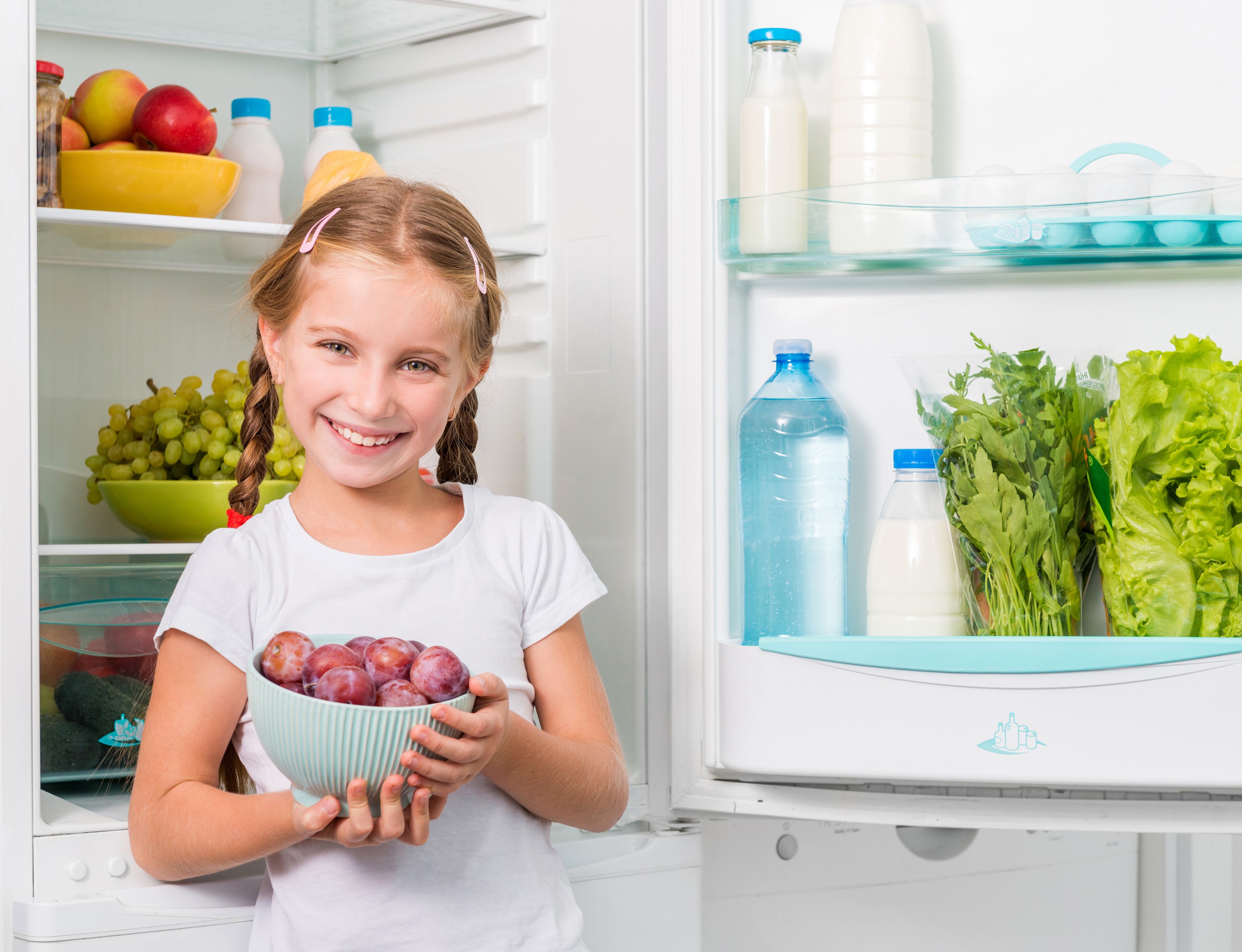 Girl holding plums in front of an open refrigerator HD Wallpaper