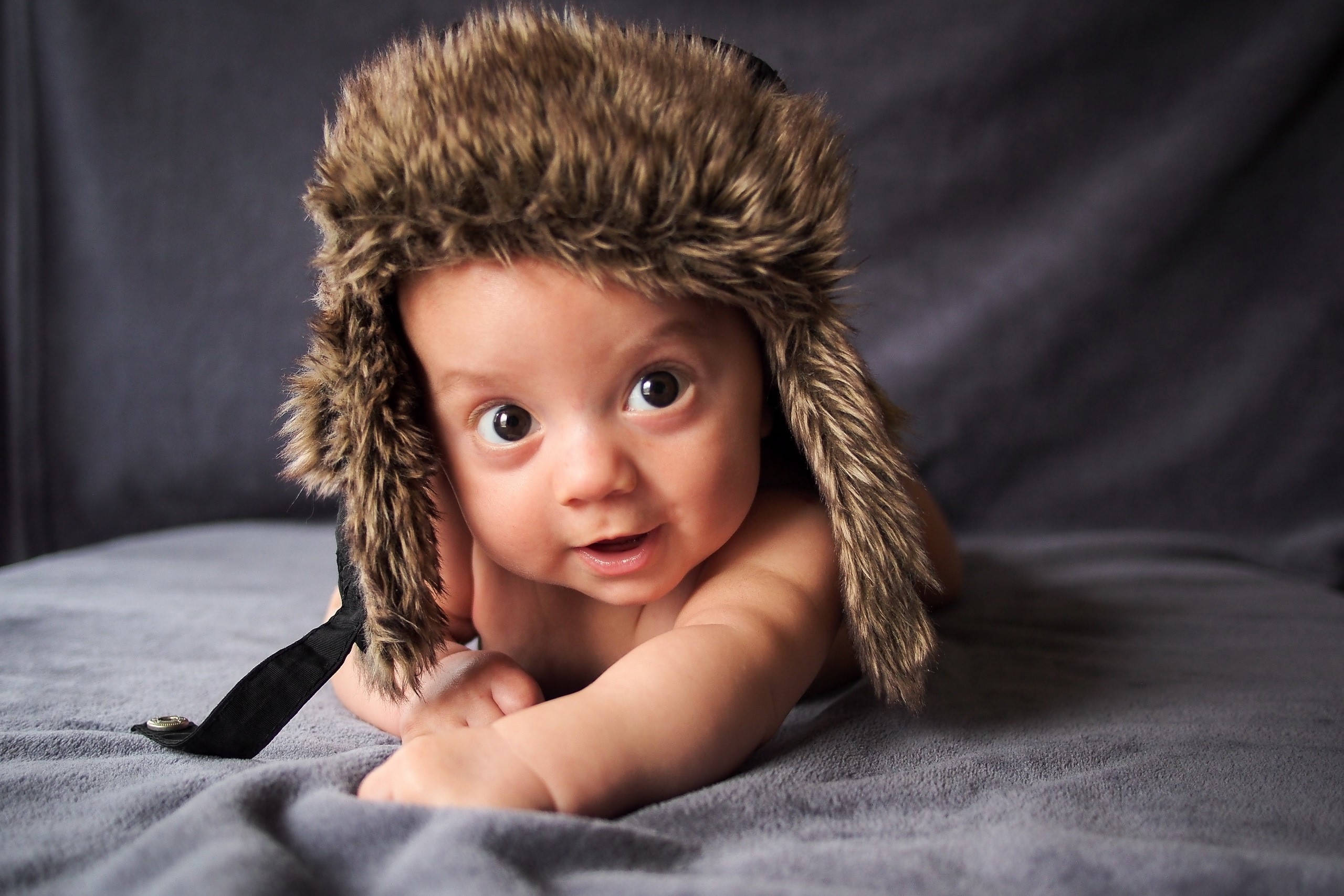 Baby wearing a furry winter hat HD Wallpaper
