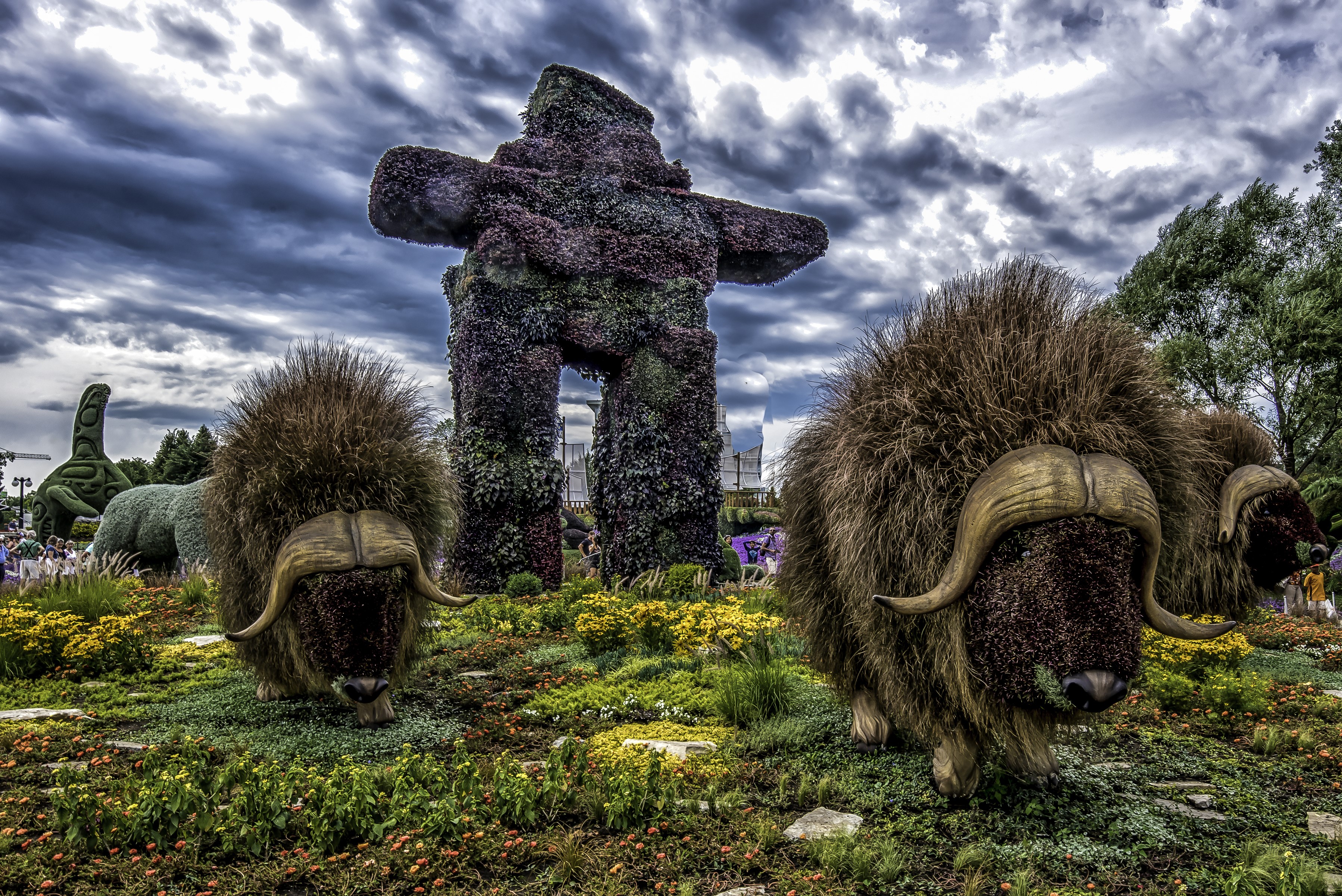 Inukshuk and muskox sculptures in a park HD Wallpaper