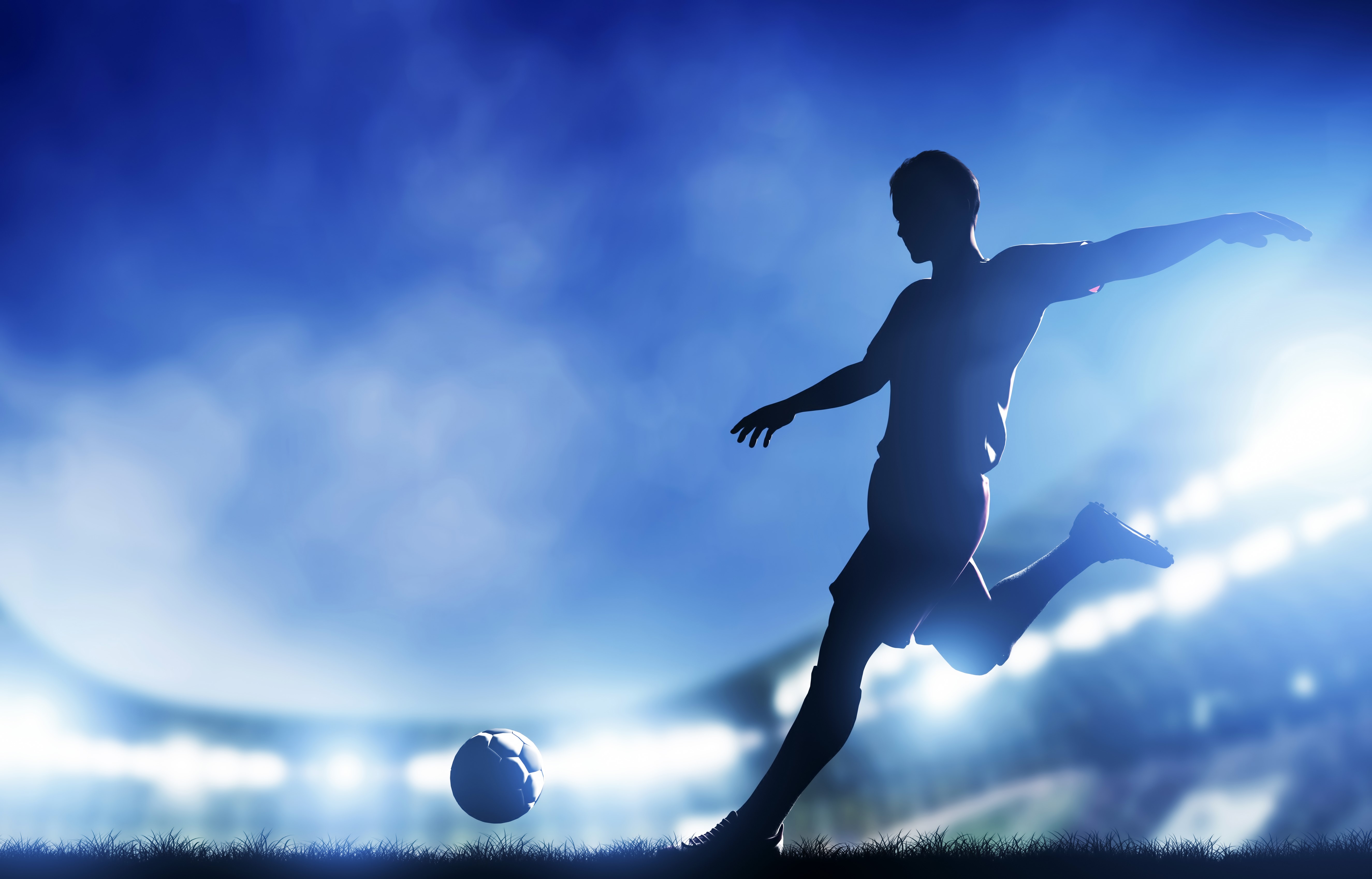 Silhouette of a man kicking a soccer ball HD Wallpaper