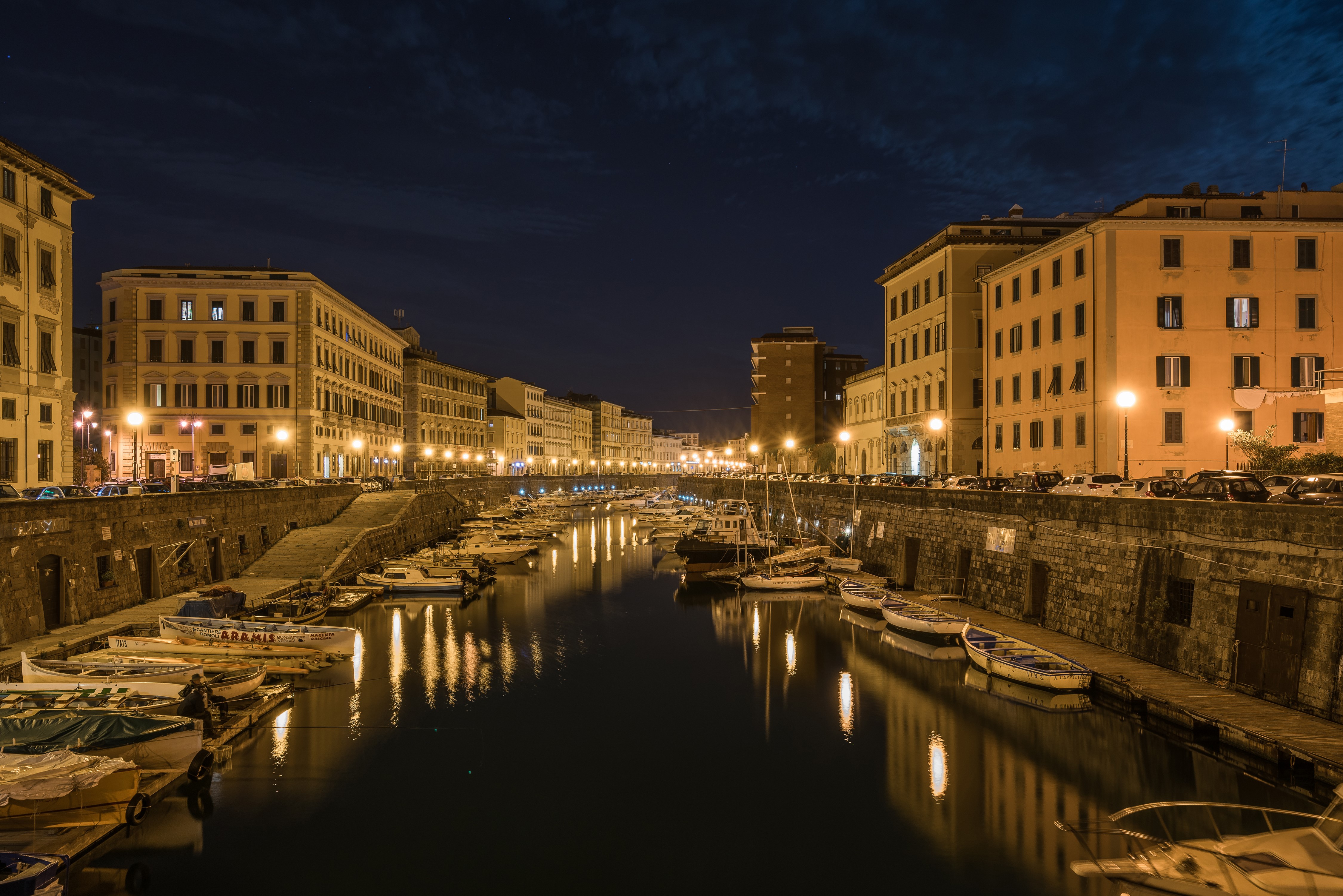 Night view of canal with boats and buildings in Livorno, Italy HD Wallpaper