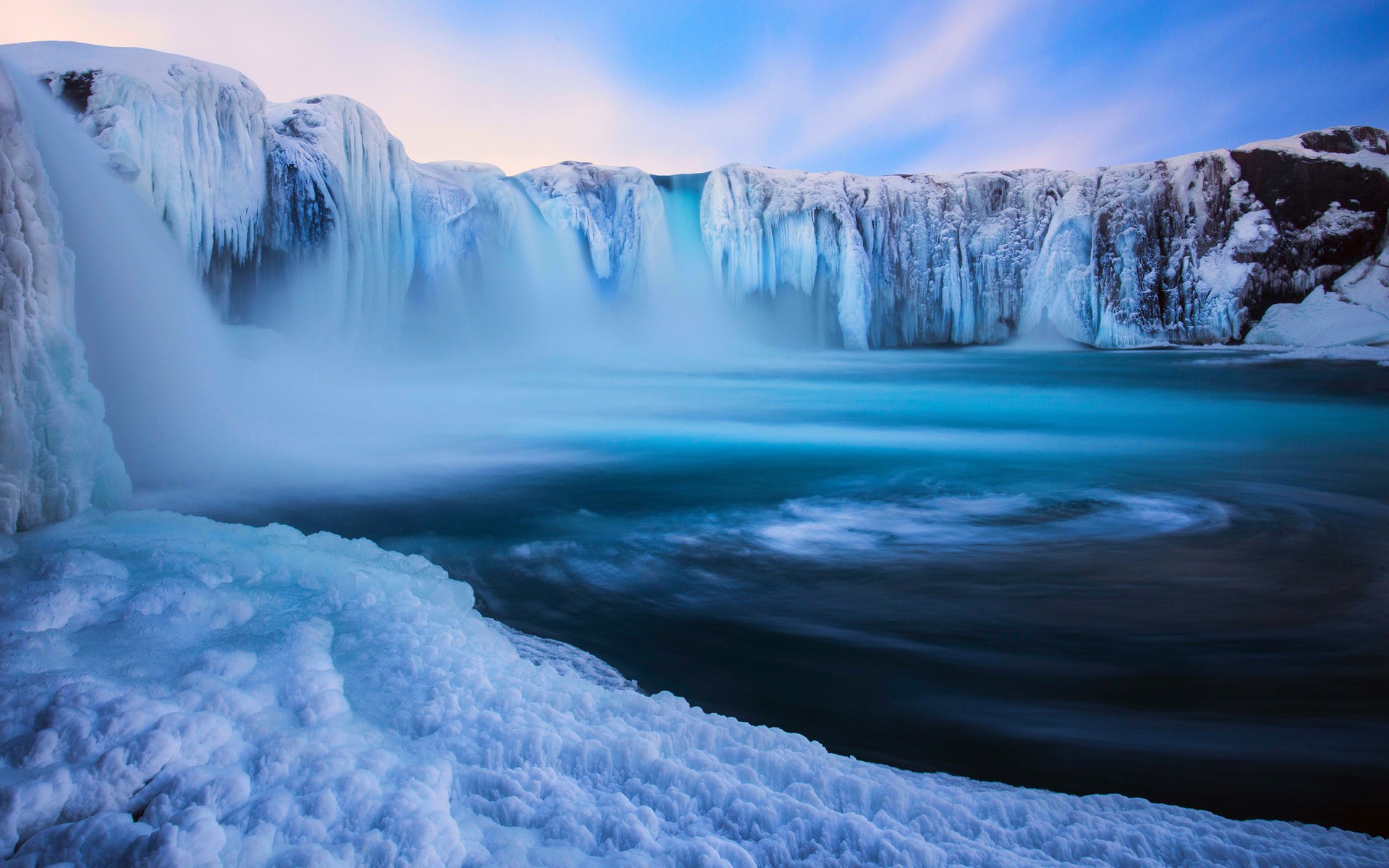 Frozen waterfall with icy formations and blue water HD Wallpaper