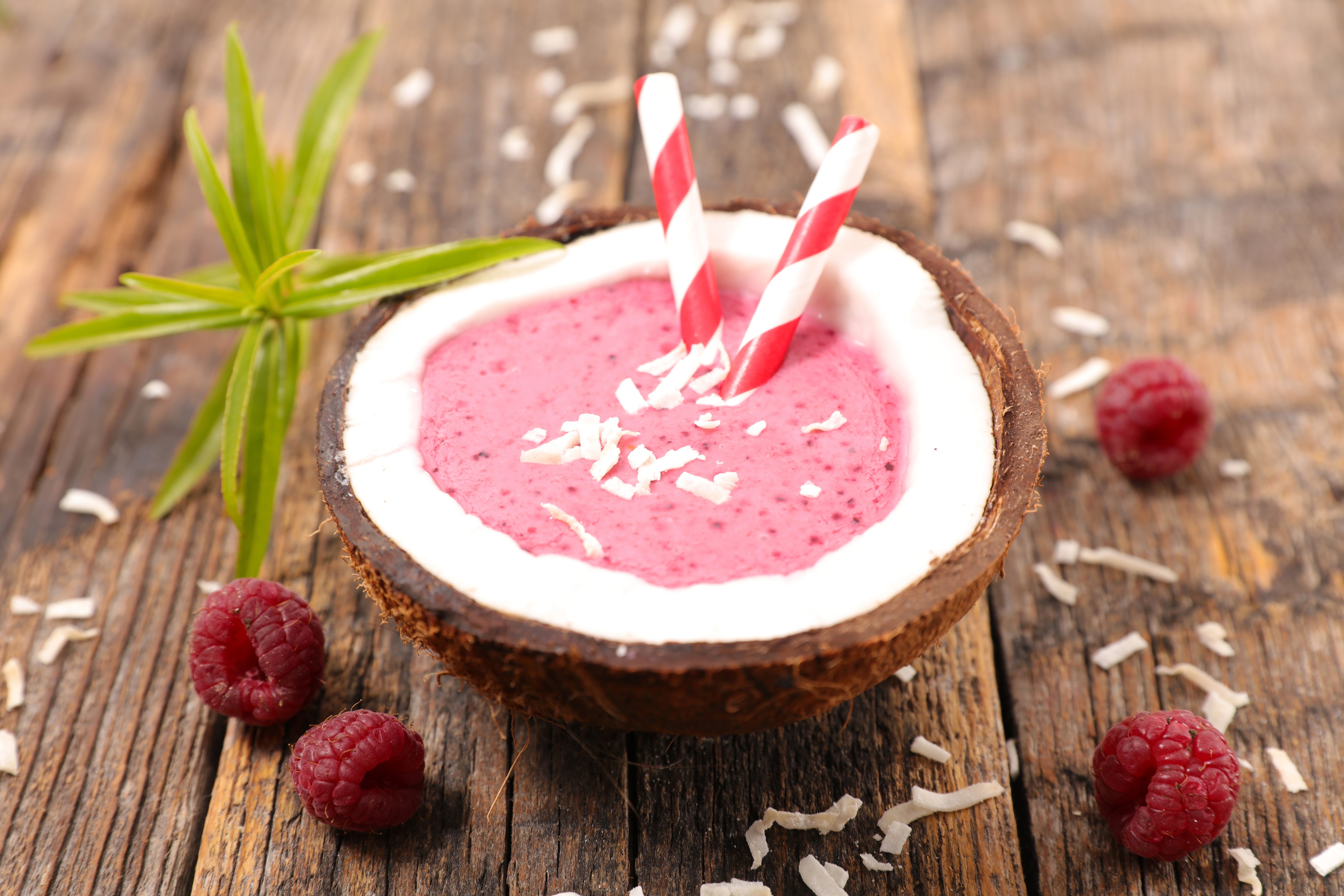 Raspberry smoothie in a coconut with straws HD Wallpaper