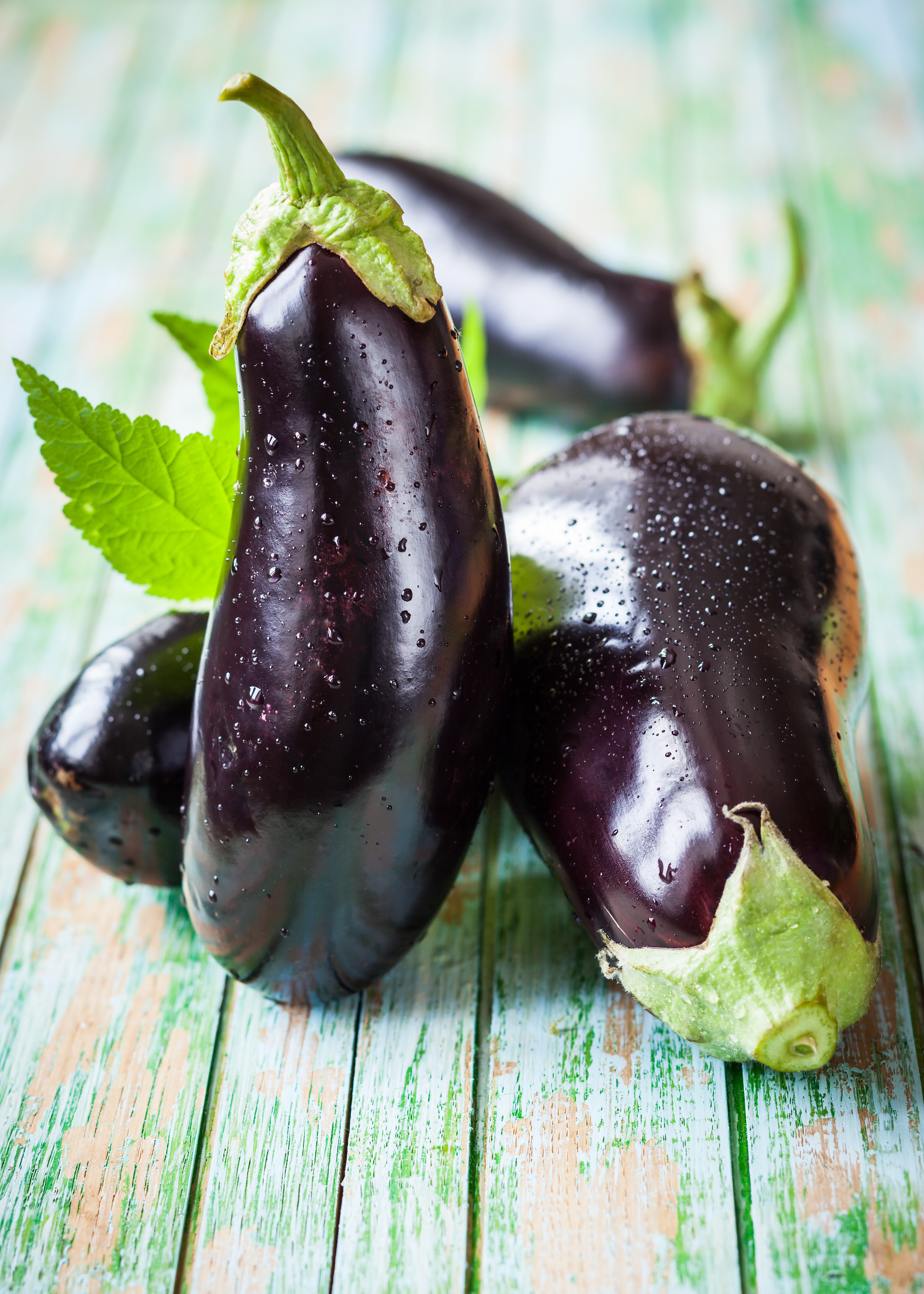 Fresh eggplants on a wooden surface HD Phone Wallpaper